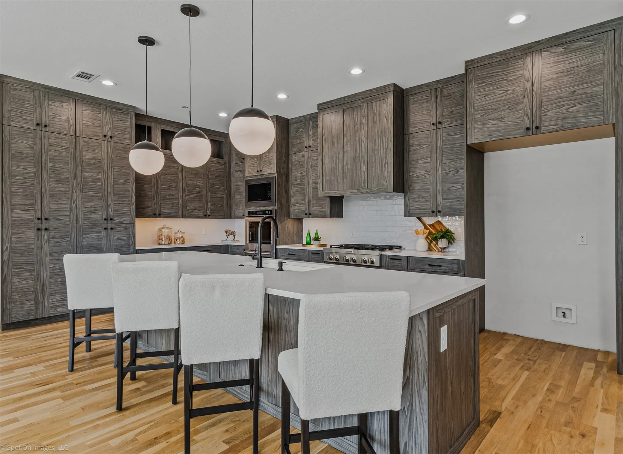 Kitchen featuring wood-finish cabinetry, a central island with countertop, and pendant lighting
