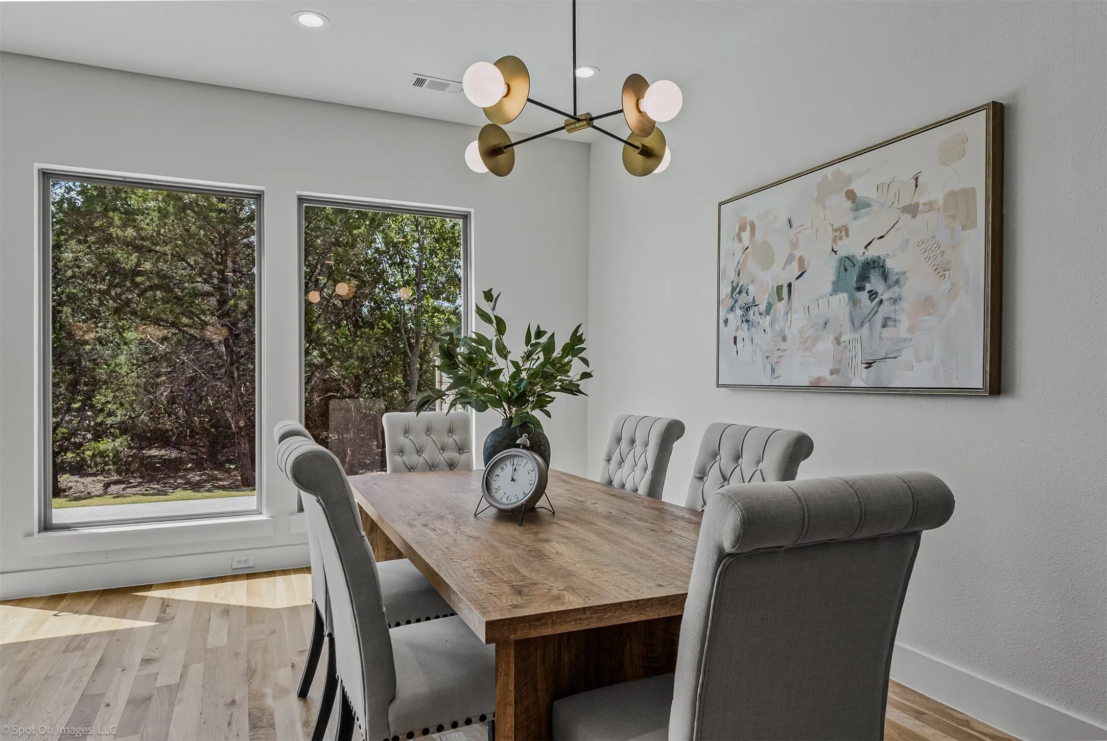 Hardwood flooring with large windows, recessed lighting, and a modern chandelier