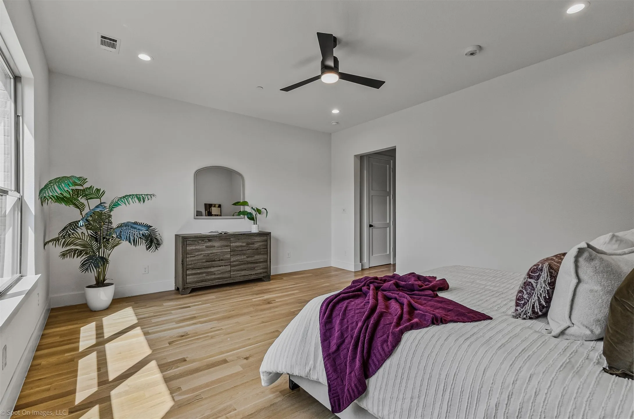 Recessed lighting, light wood-finish flooring, high ceilings, large window, and ceiling fan