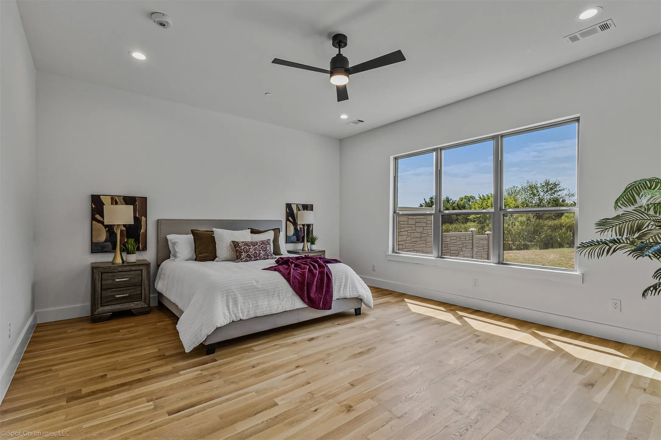Light wood-finish flooring, recessed lighting, and a ceiling fan with integrated lighting
