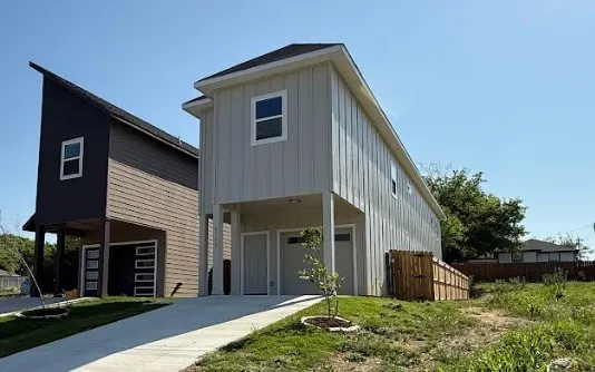 Contemporary exterior with board and batten siding, multiple windows, and a concrete driveway