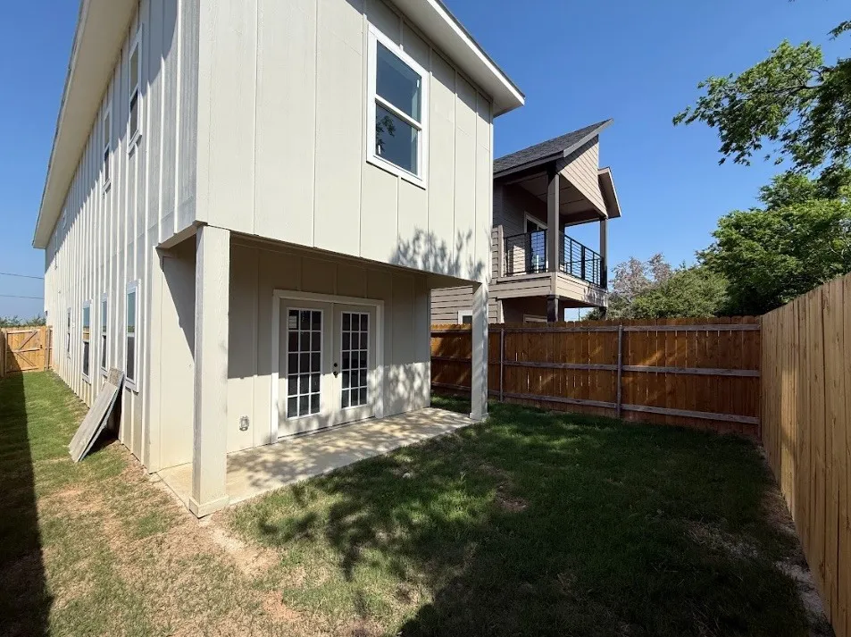 Private fenced yard featuring a concrete patio and direct access via double French doors