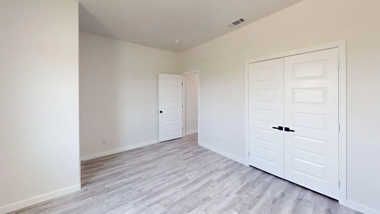 Light-toned wood-finish flooring complements the neutral wall color