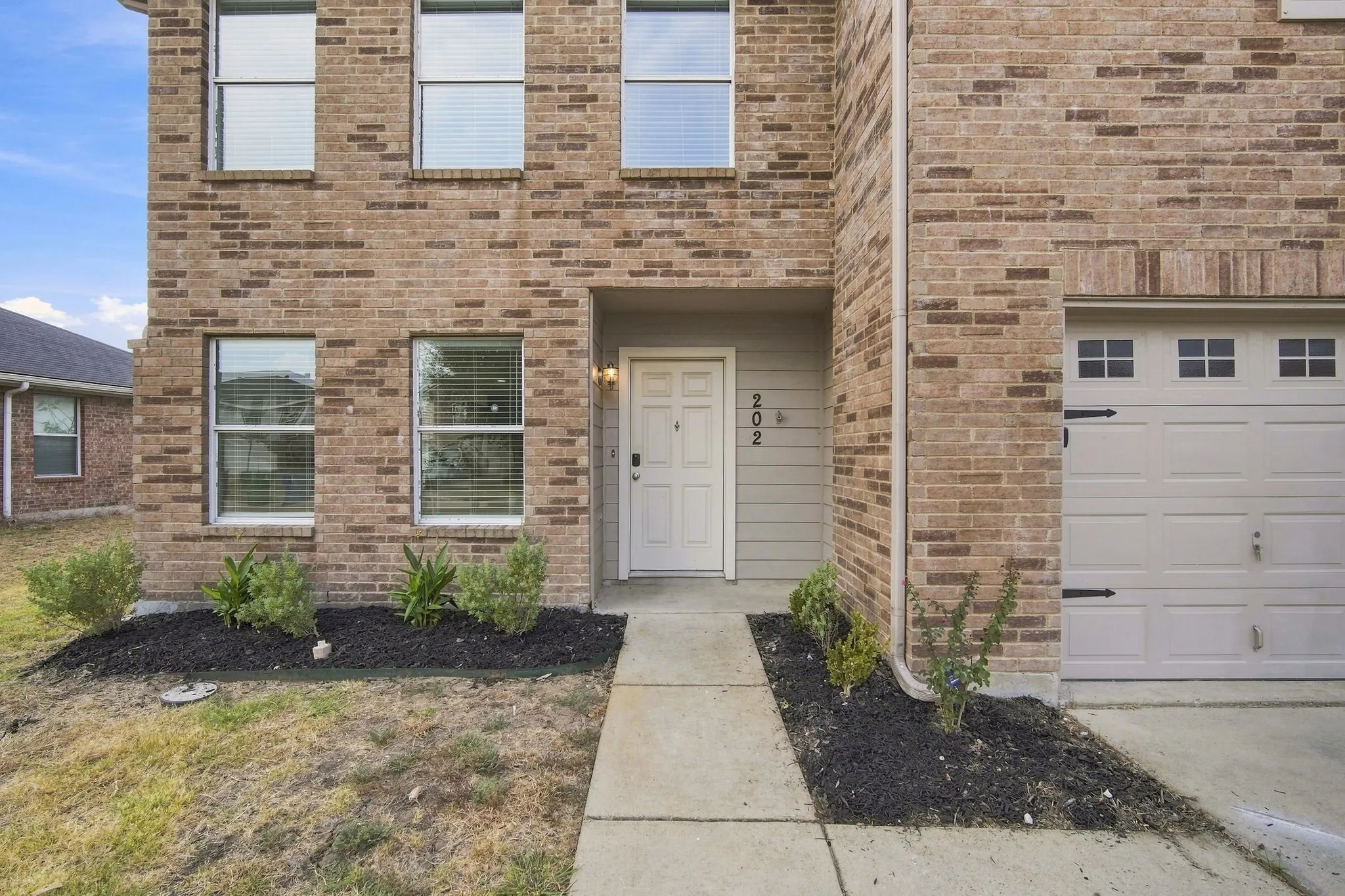 Inviting entry with fresh landscaping