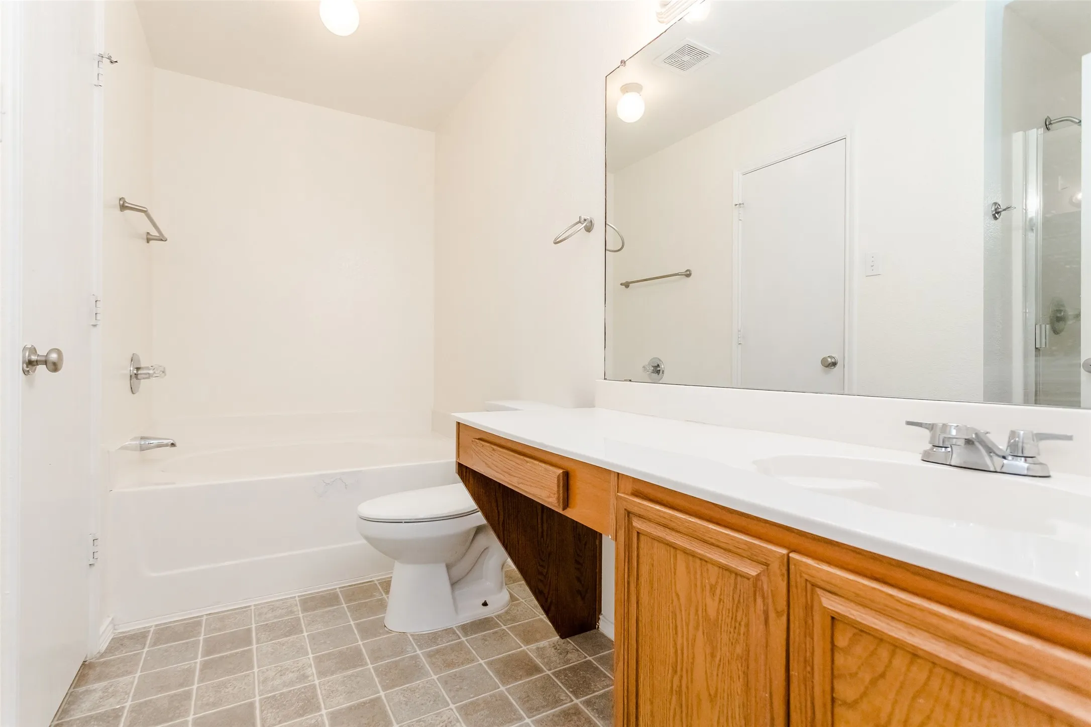 Bathroom with vanity, a bath, toilet, and tile patterned floors