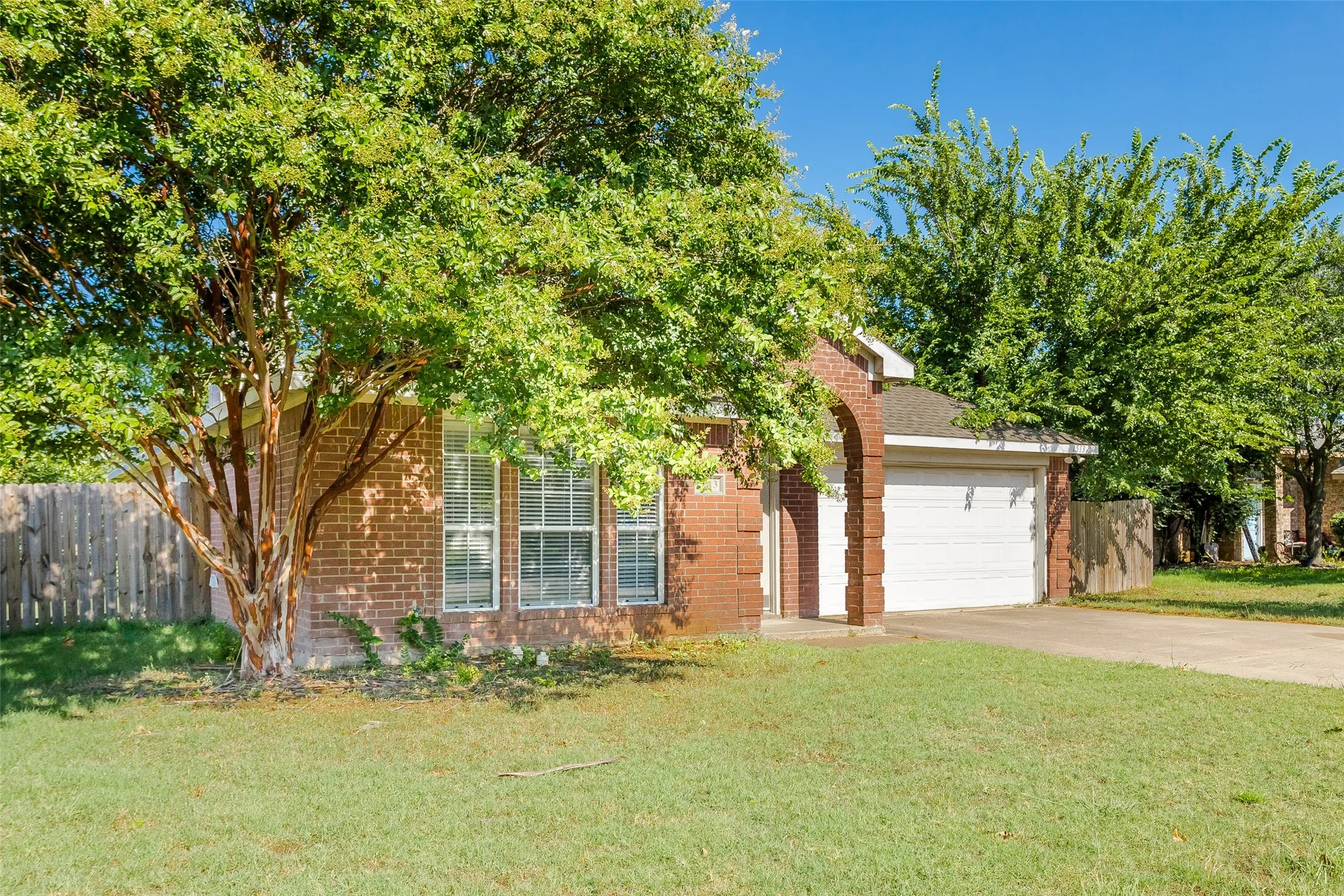 Obstructed view of property featuring a garage and a front lawn