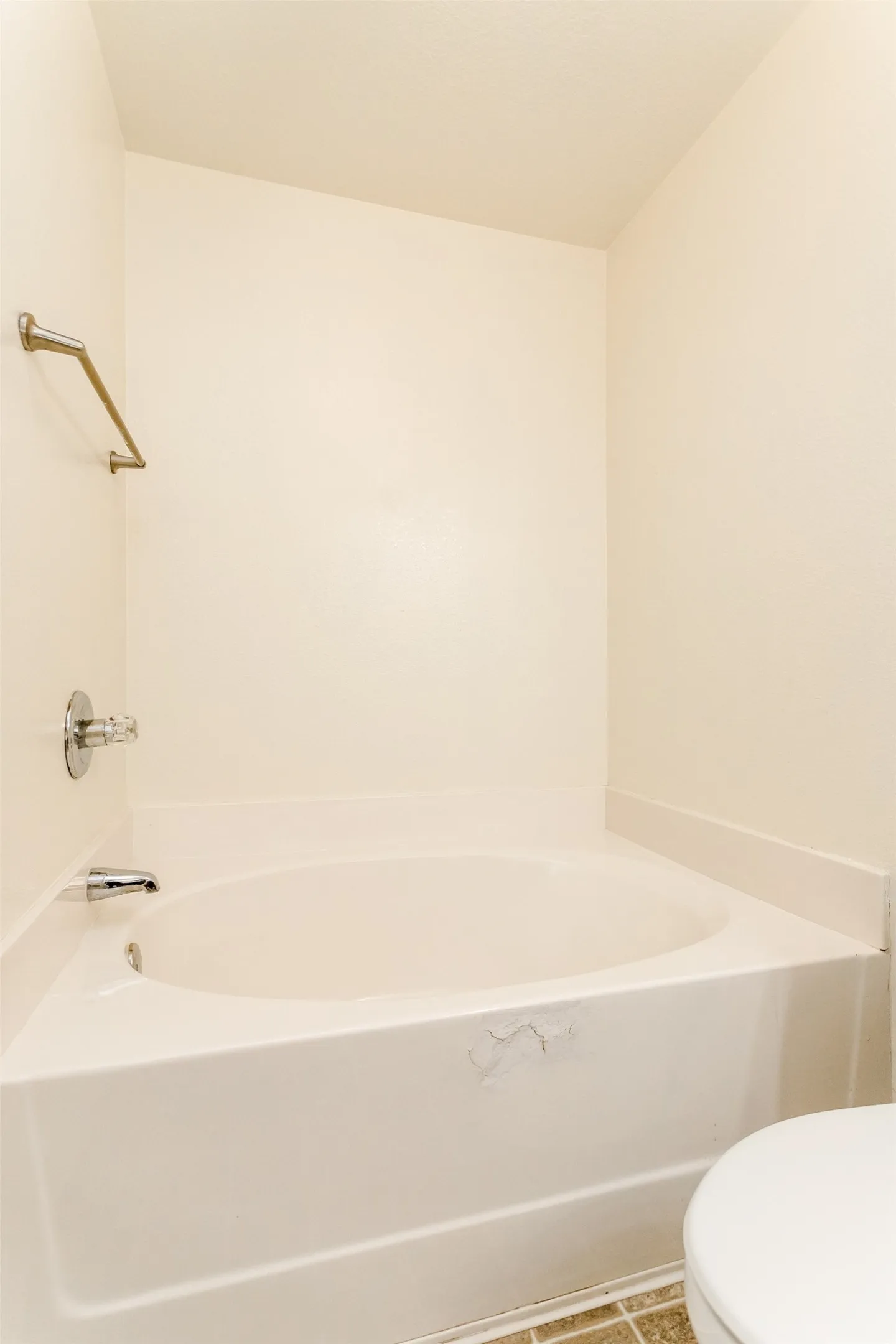 Bathroom with toilet, tile patterned floors, and a bath