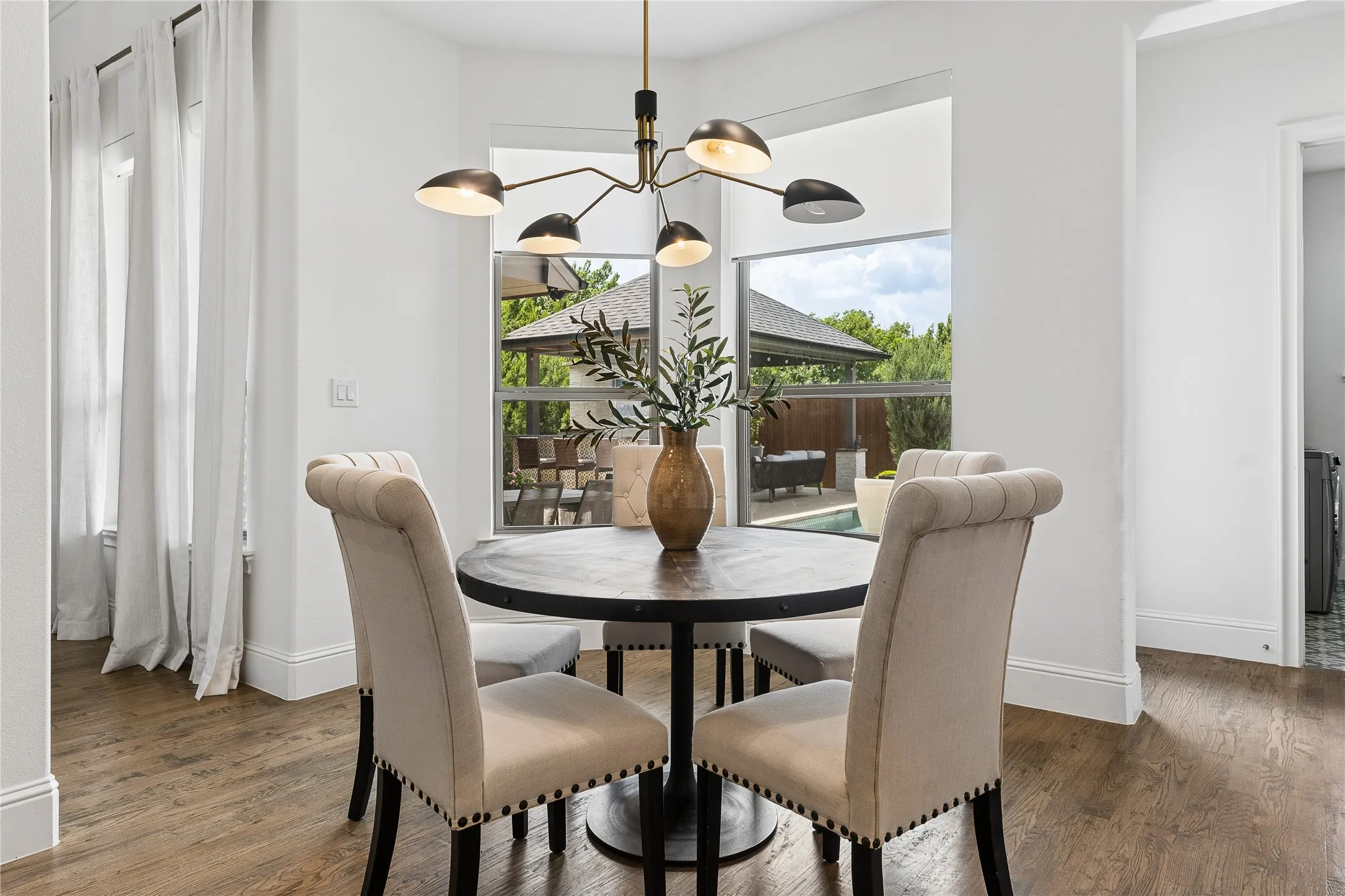 Breakfast room surrounded by windows with seamless access to the family room and outdoor living spaces