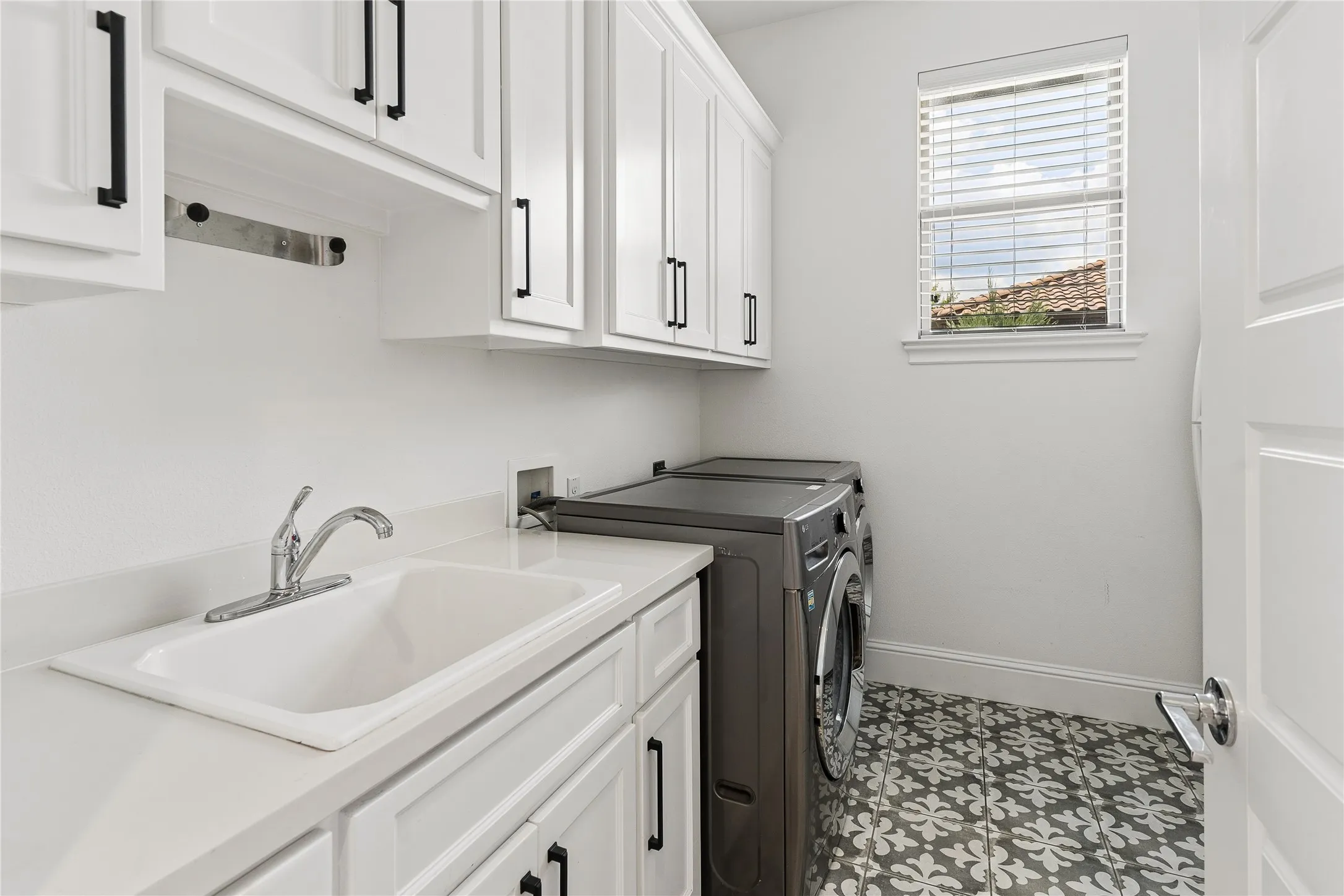 Oversized utility room with extensive cabinetry, abundant storage, and space for a second refrigerator