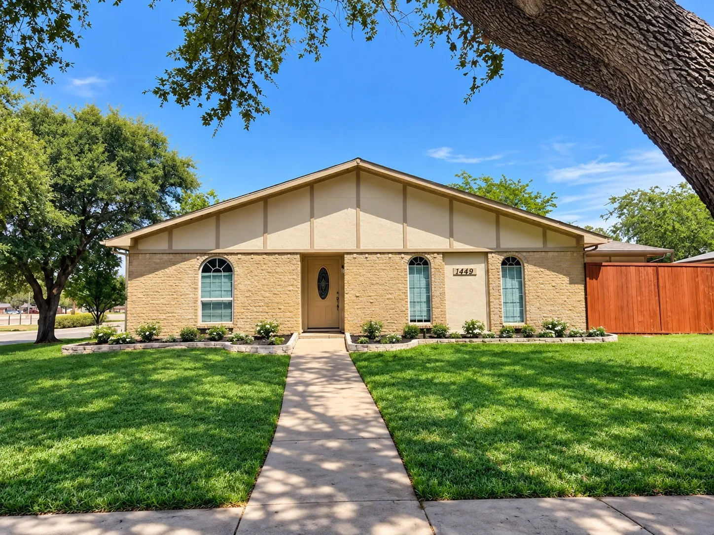 Digitally Enhanced Grass & Flowerbed: Brick exterior with arched windows, a pitched roof, and a concrete walkway