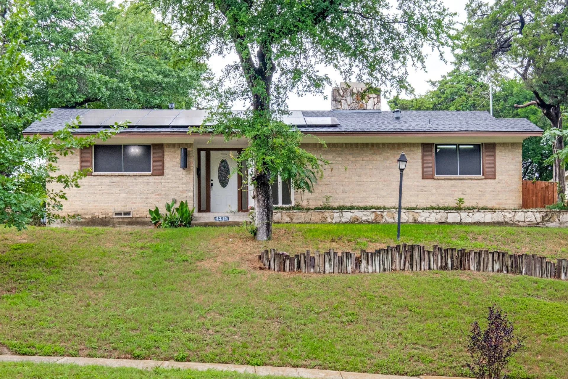 Brick exterior with a gabled roof and solar panels