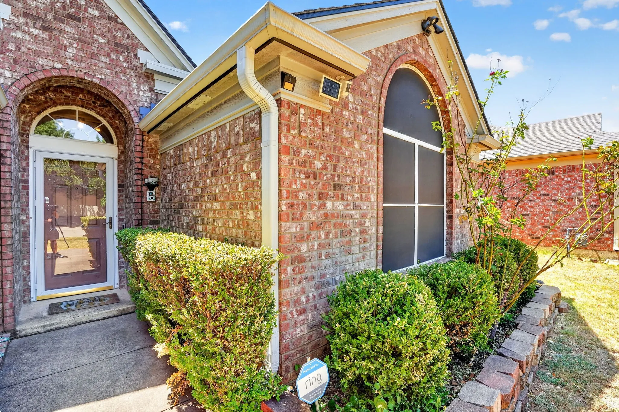 Brick exterior with a prominent arched window and a matching arched entryway