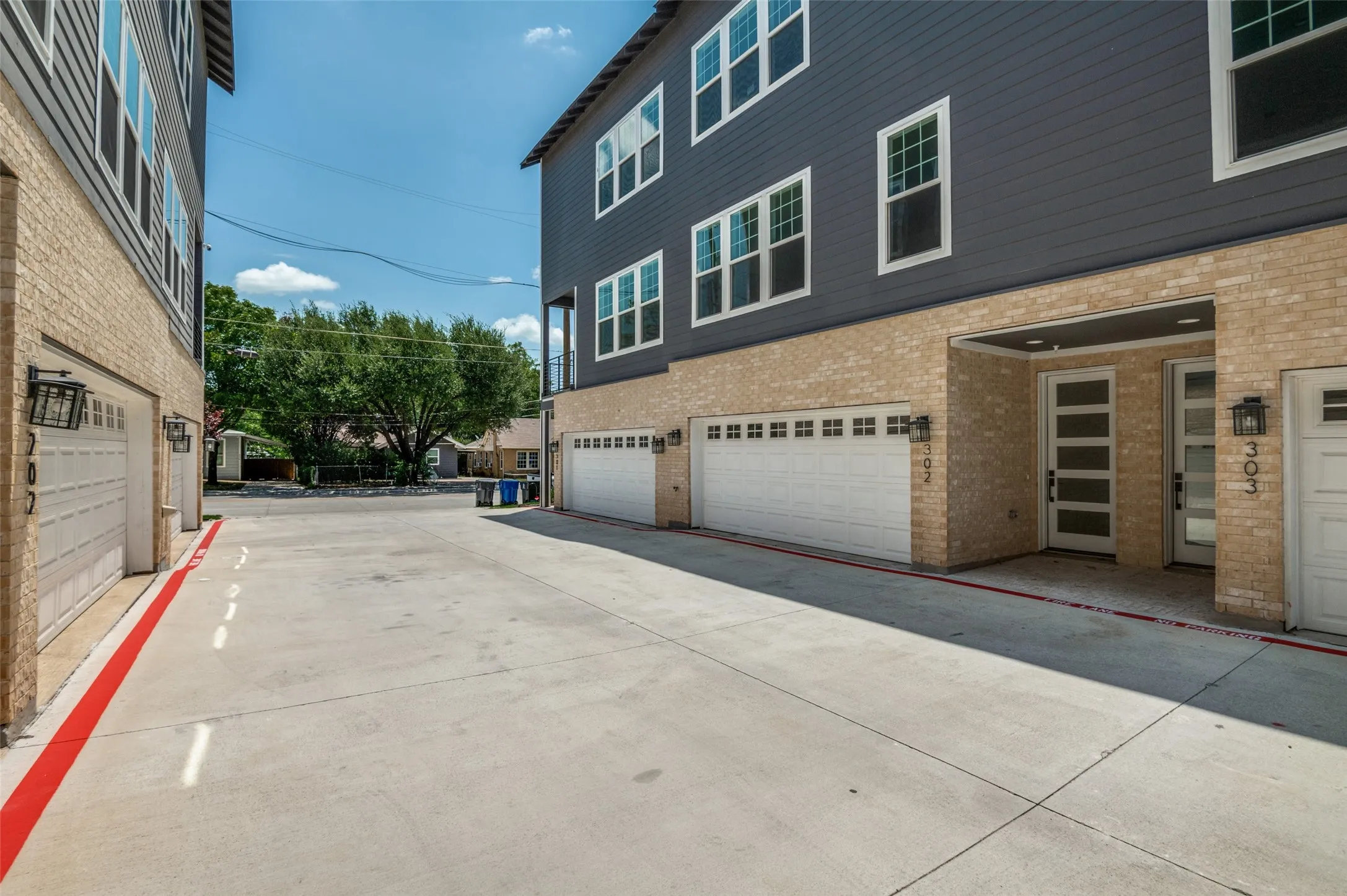 View of side of home with brick siding, a garage, and driveway