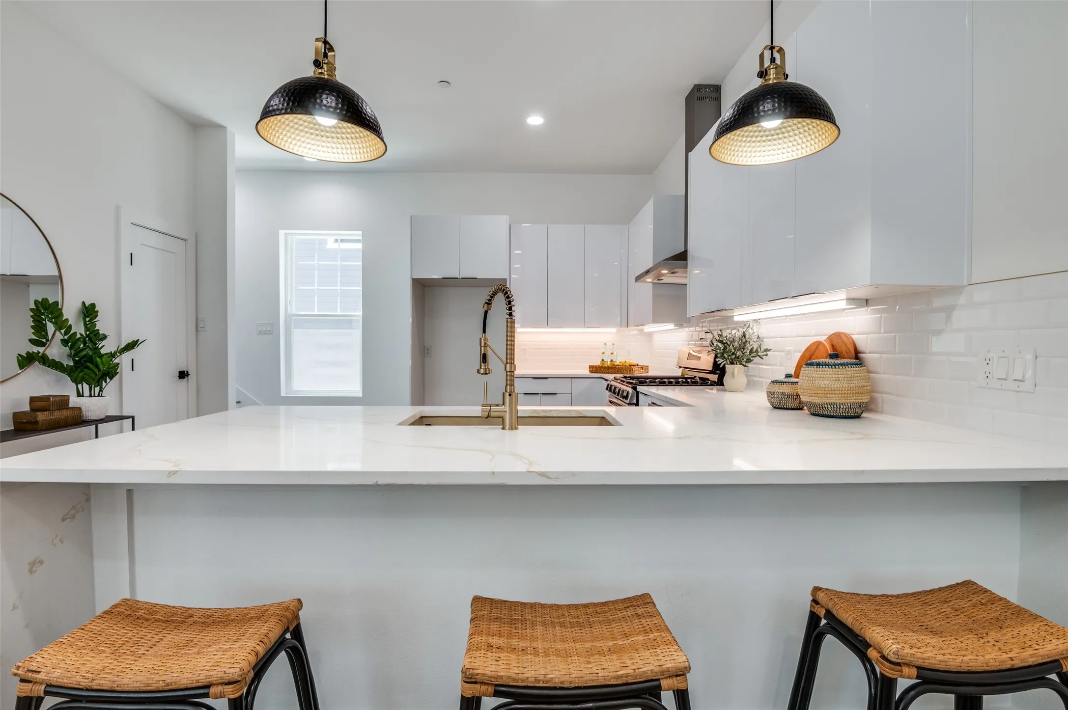 Kitchen featuring white range with gas cooktop, decorative backsplash, and decorative light fixtures