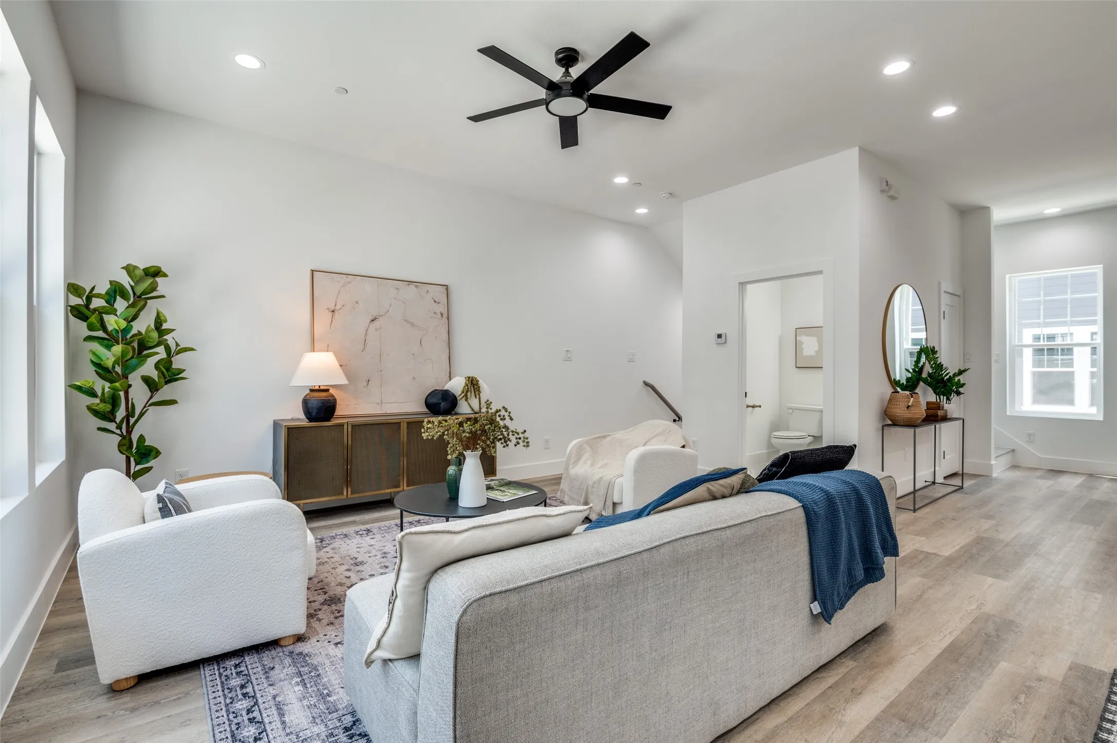 Living area featuring light wood finished floors, ceiling fan, and recessed lighting