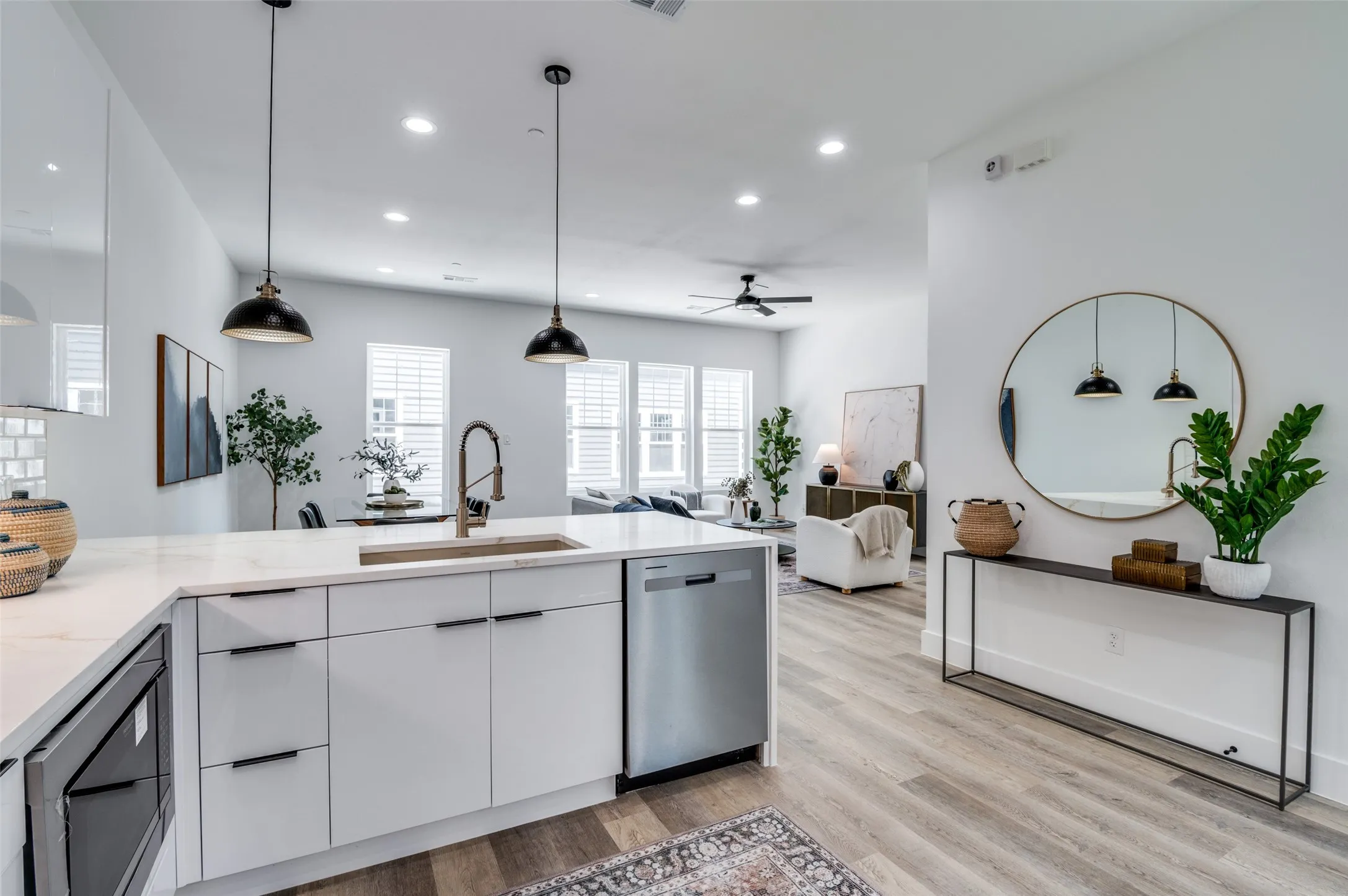 Kitchen featuring stainless steel appliances, white cabinets, recessed lighting, ceiling fan, and light wood-type flooring