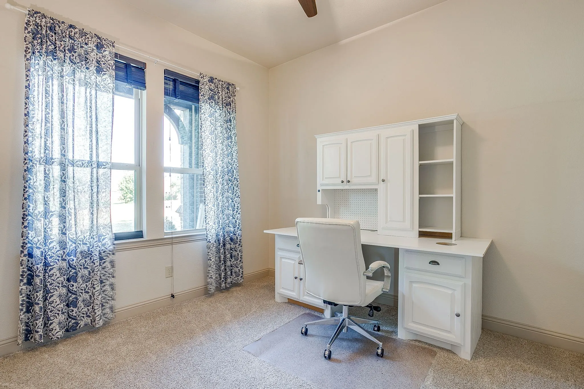 Bedroom 2 with Built-in desk with overhead cabinetry and shelving, vaulted ceiling, and two windows
