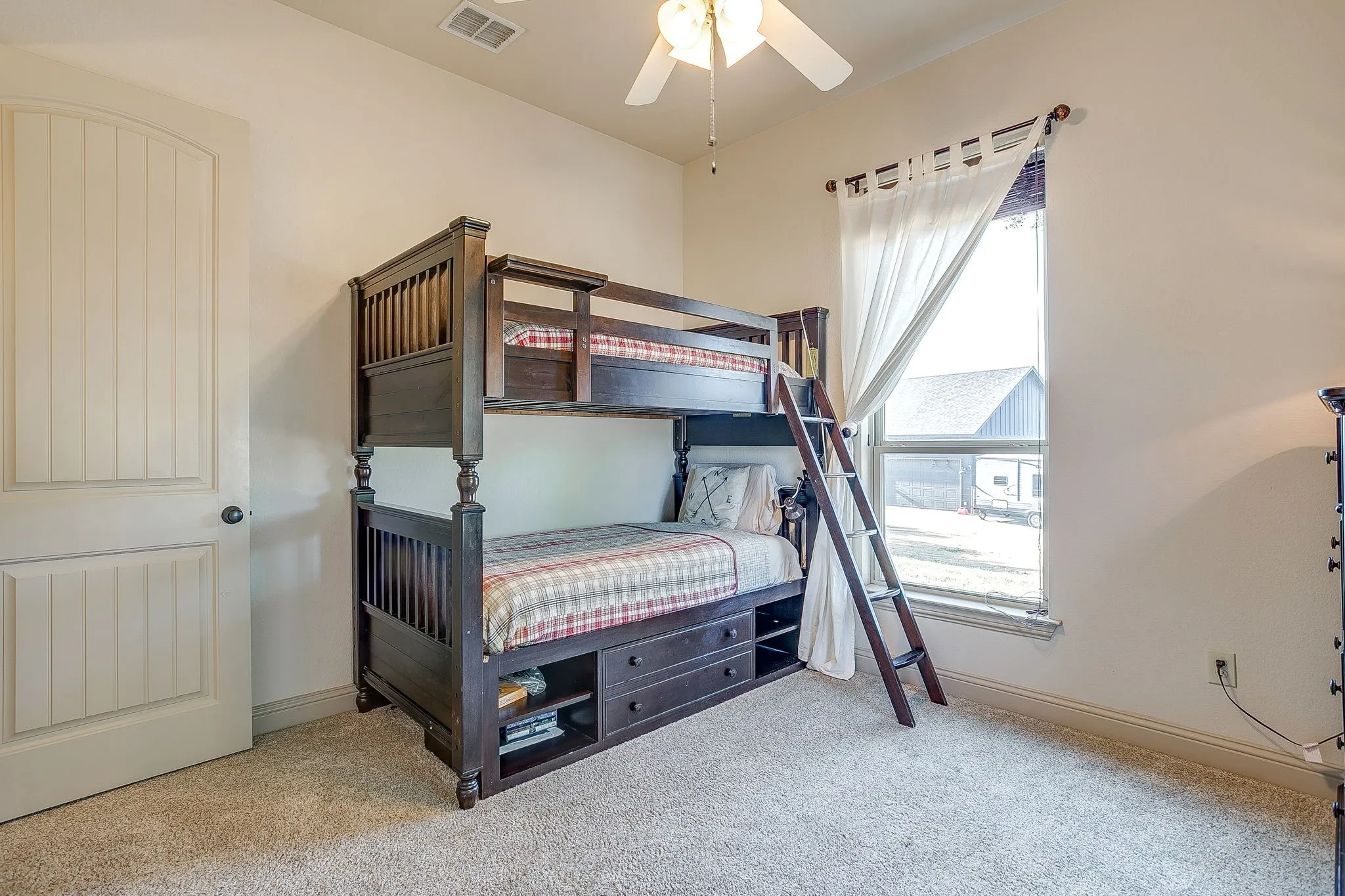 Bedroom 4 with carpet flooring, ceiling fan, natural light window, and panel door