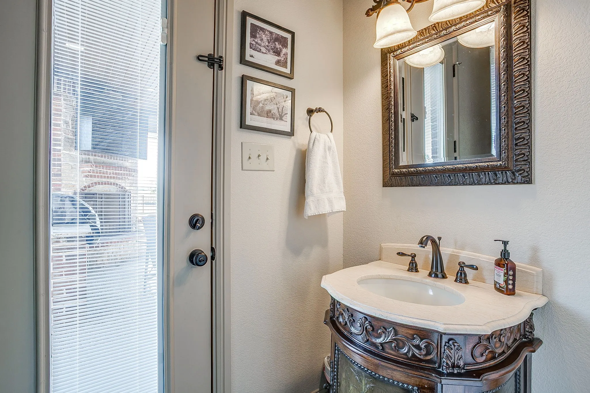 Ornate vanity with single basin, dual-handle faucet, and light-colored countertop