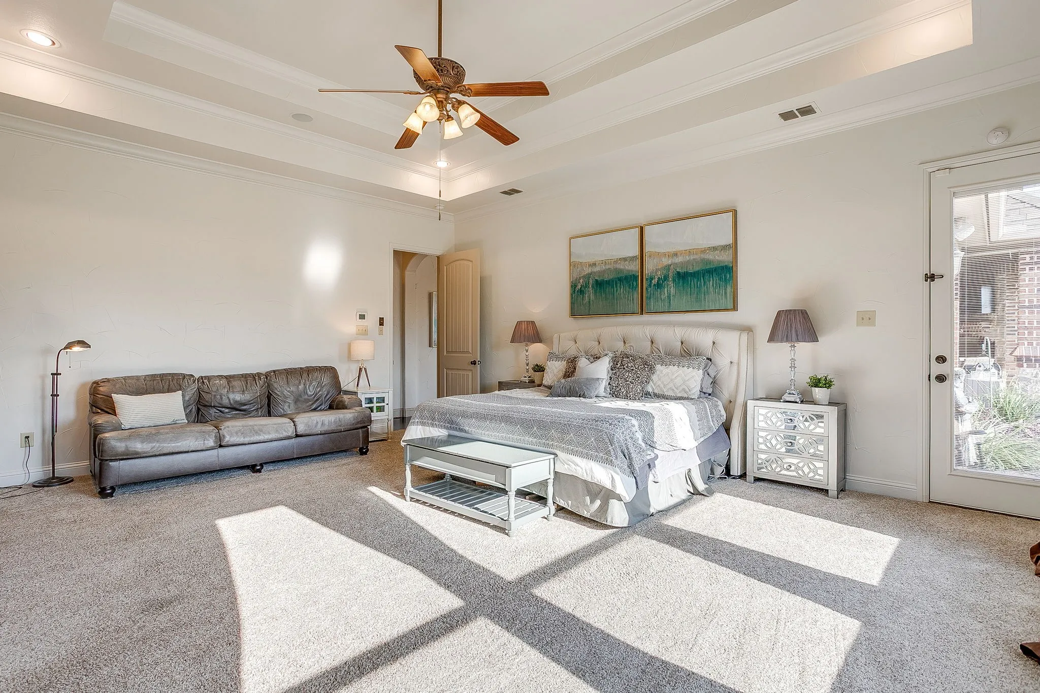 Tray ceiling with crown molding, ceiling fan, and recessed lighting
