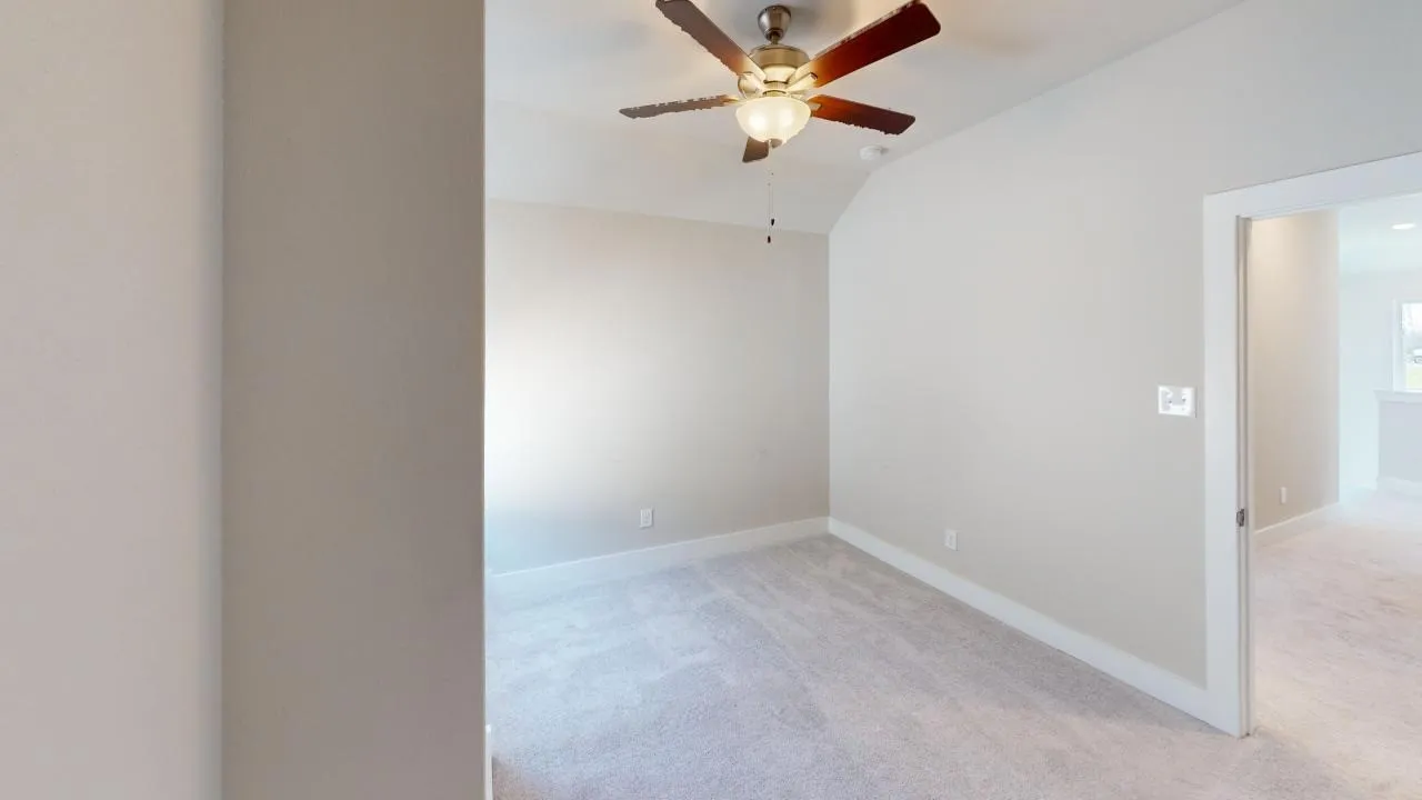 Vaulted ceiling with a ceiling fan, light gray carpet, and white trim