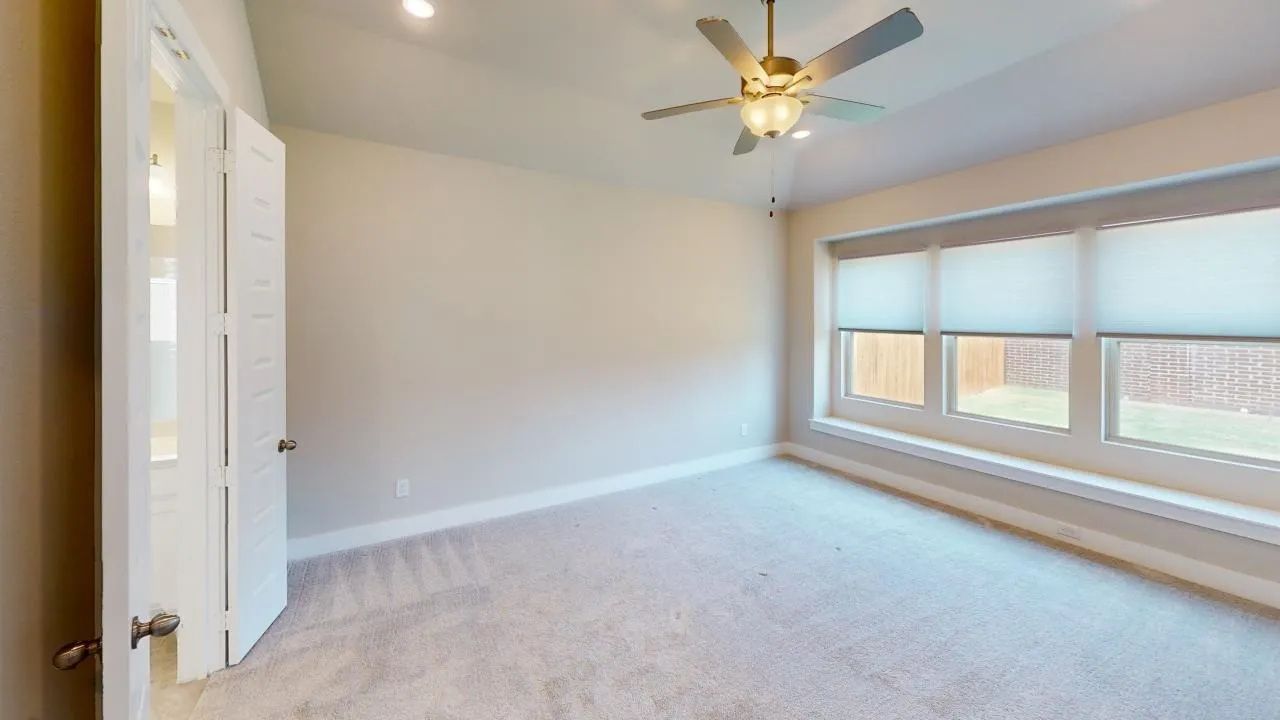 Spacious room with plush carpeting, recessed lighting, and a ceiling fan
