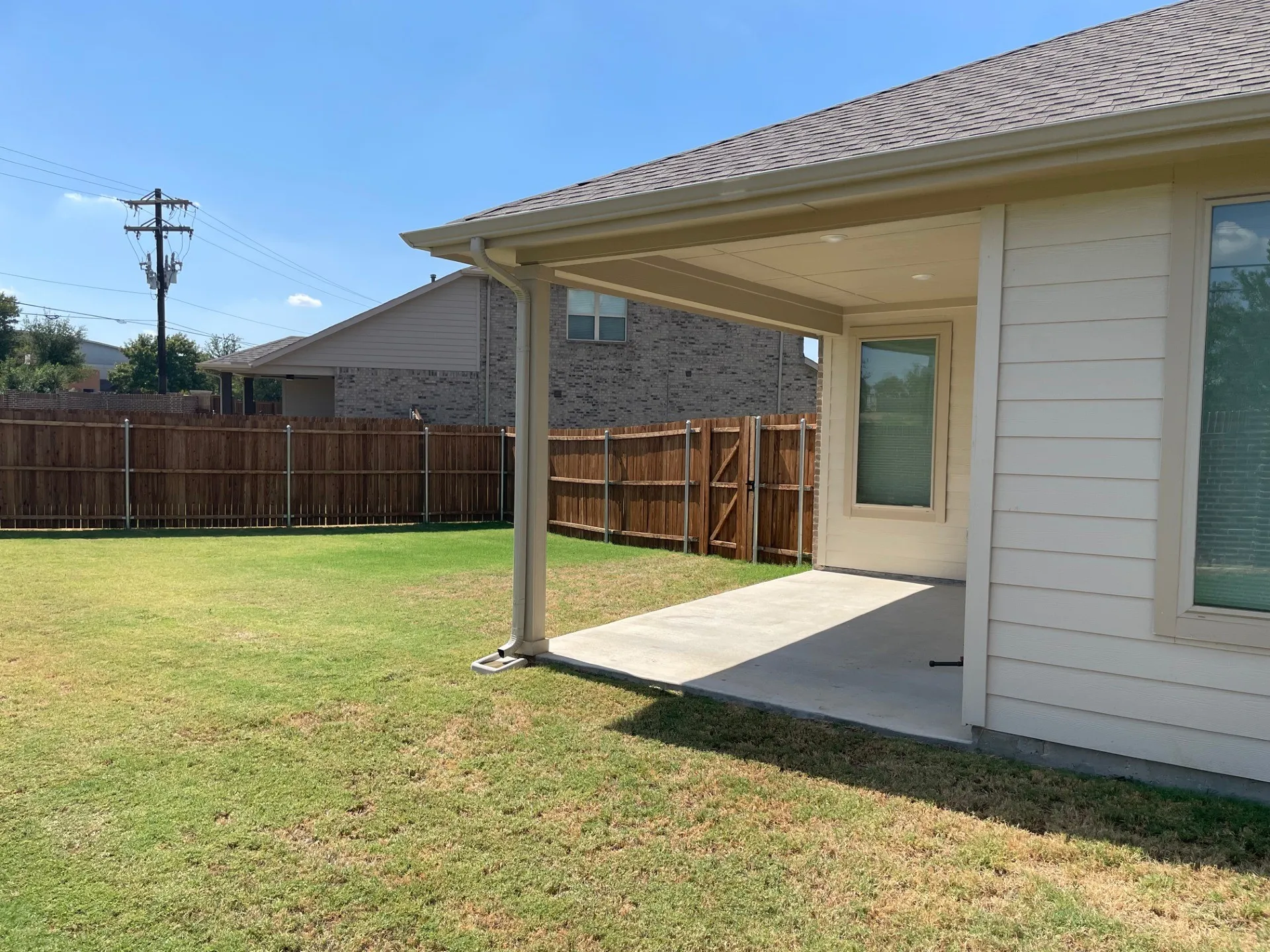 Covered patio with concrete flooring, recessed lighting, and a wood privacy fence