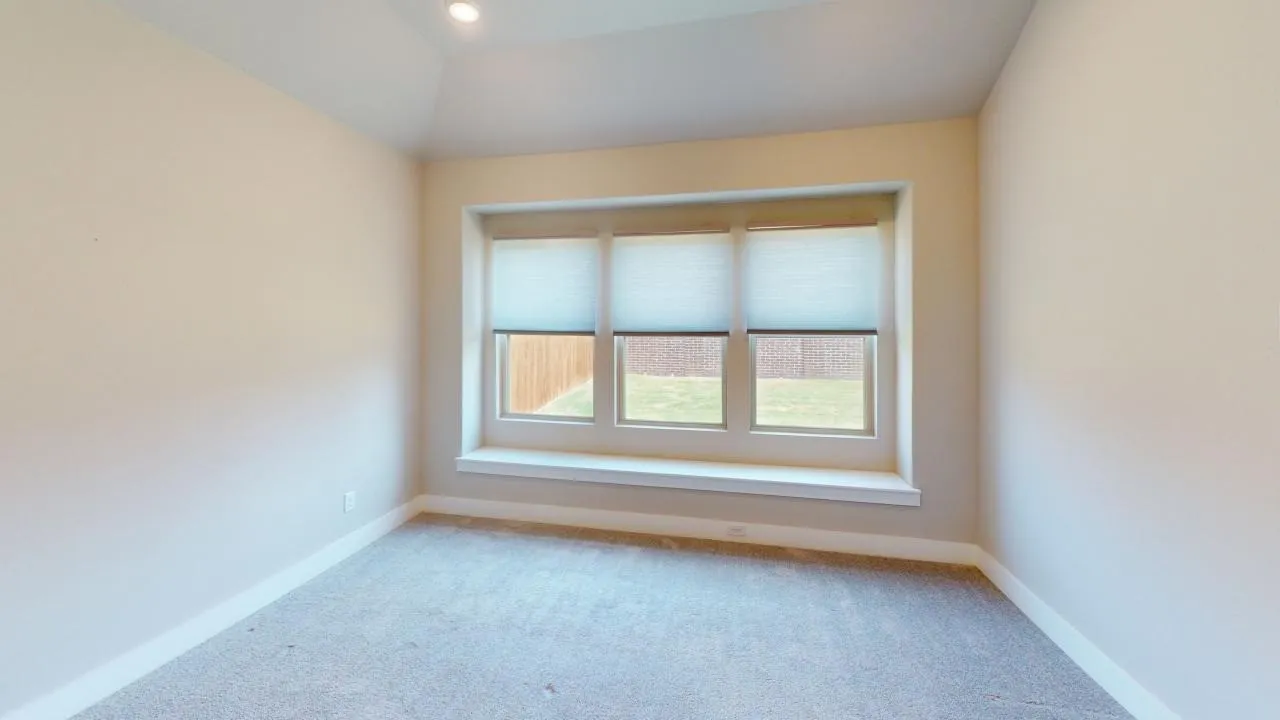 Recessed ceiling lighting, textured carpeting, large multi-pane window, integrated window seat, and neutral wall tones