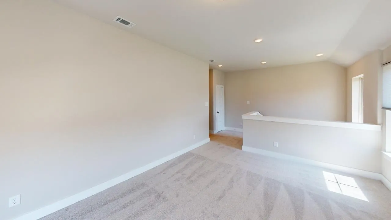 Recessed lighting, light-toned walls, and carpet flooring contribute to a bright, spacious room