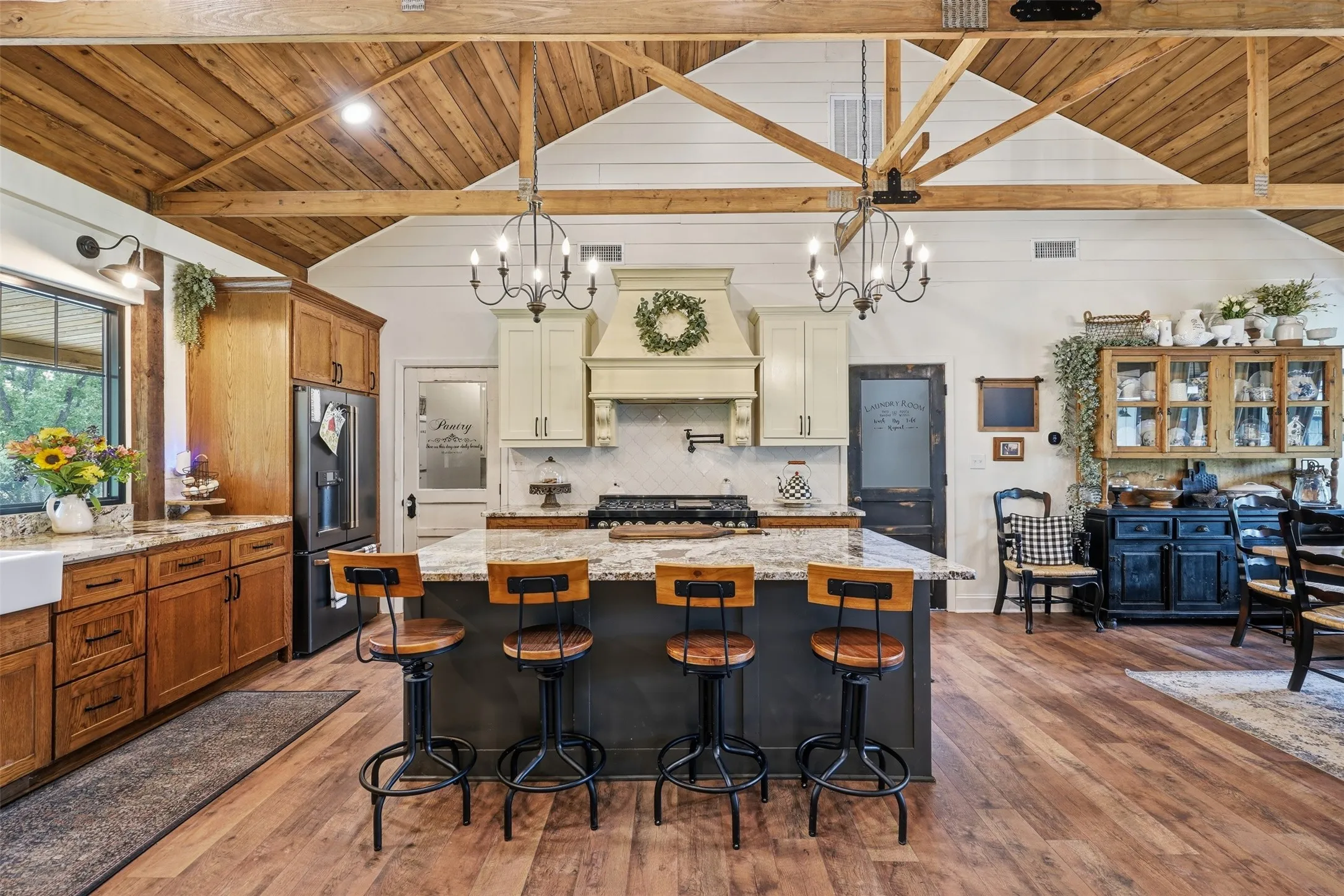gourmet kitchen, large island commercial grade stove with pot filler, multiple chandeliers