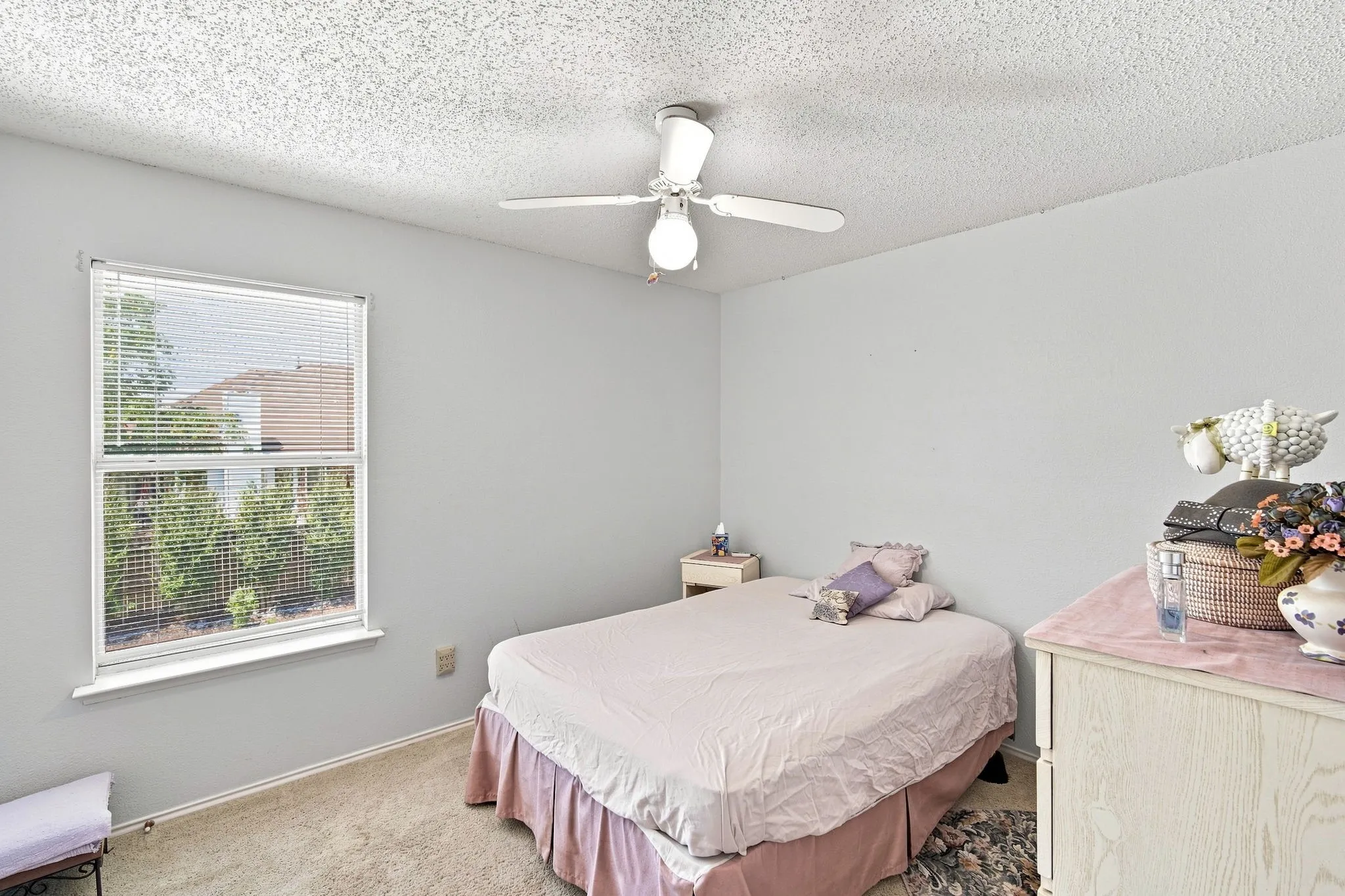 Ceiling fan with integrated lighting, window with blinds, light-colored carpeting, and painted walls