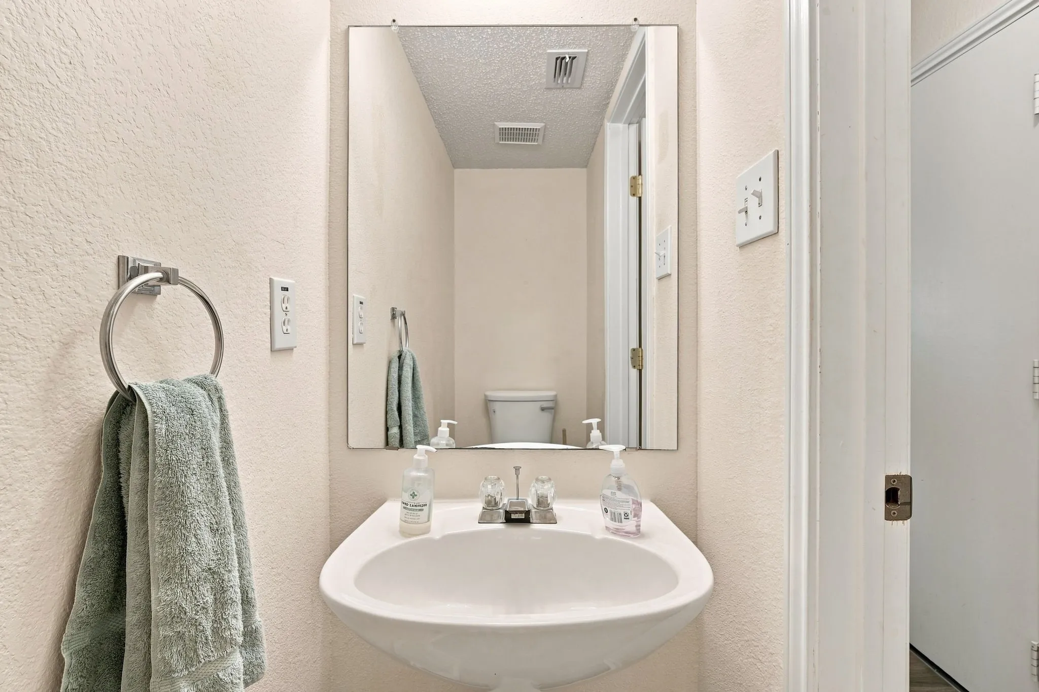 Wall-mounted sink with a single-handle chrome faucet and a rectangular mirror