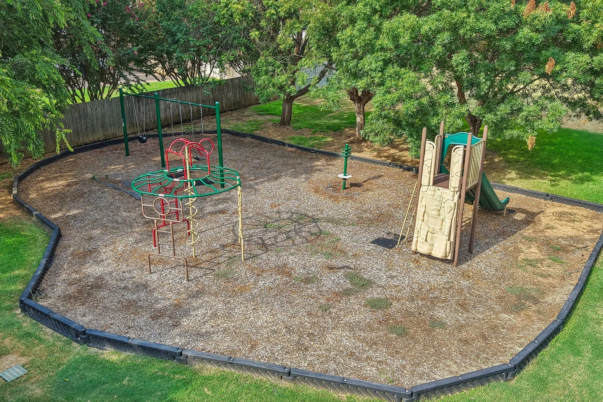 Recreational area featuring a swing set, climbing structure, and slide