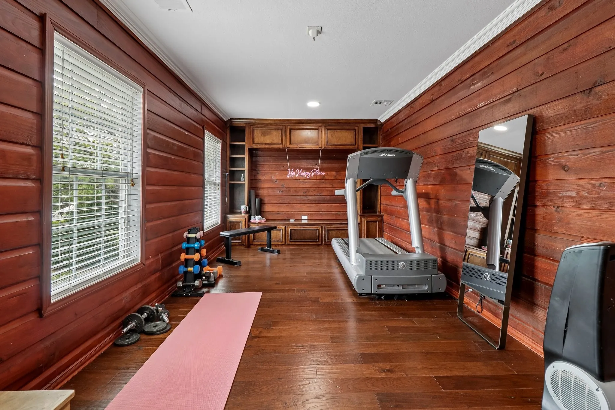 Wood-paneled walls, built-in wooden cabinetry, recessed lighting, crown molding, and wood-finish flooring