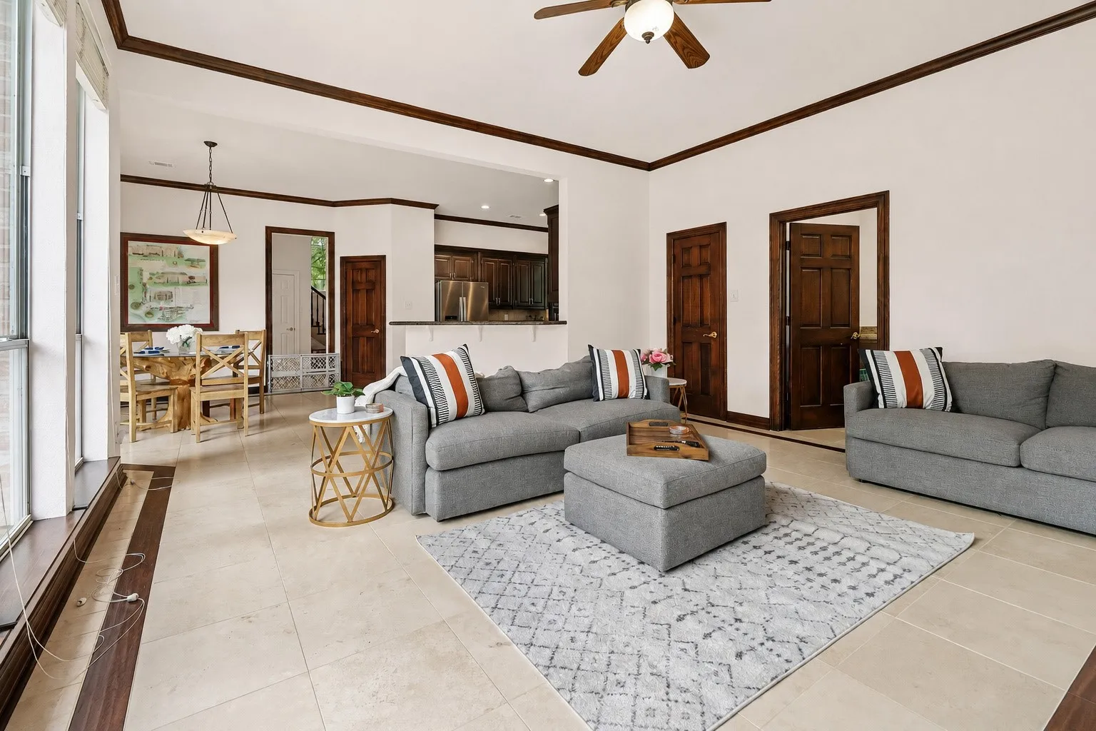 Spacious room featuring tile flooring with wood-finish inlay, large window, and dark wood trim