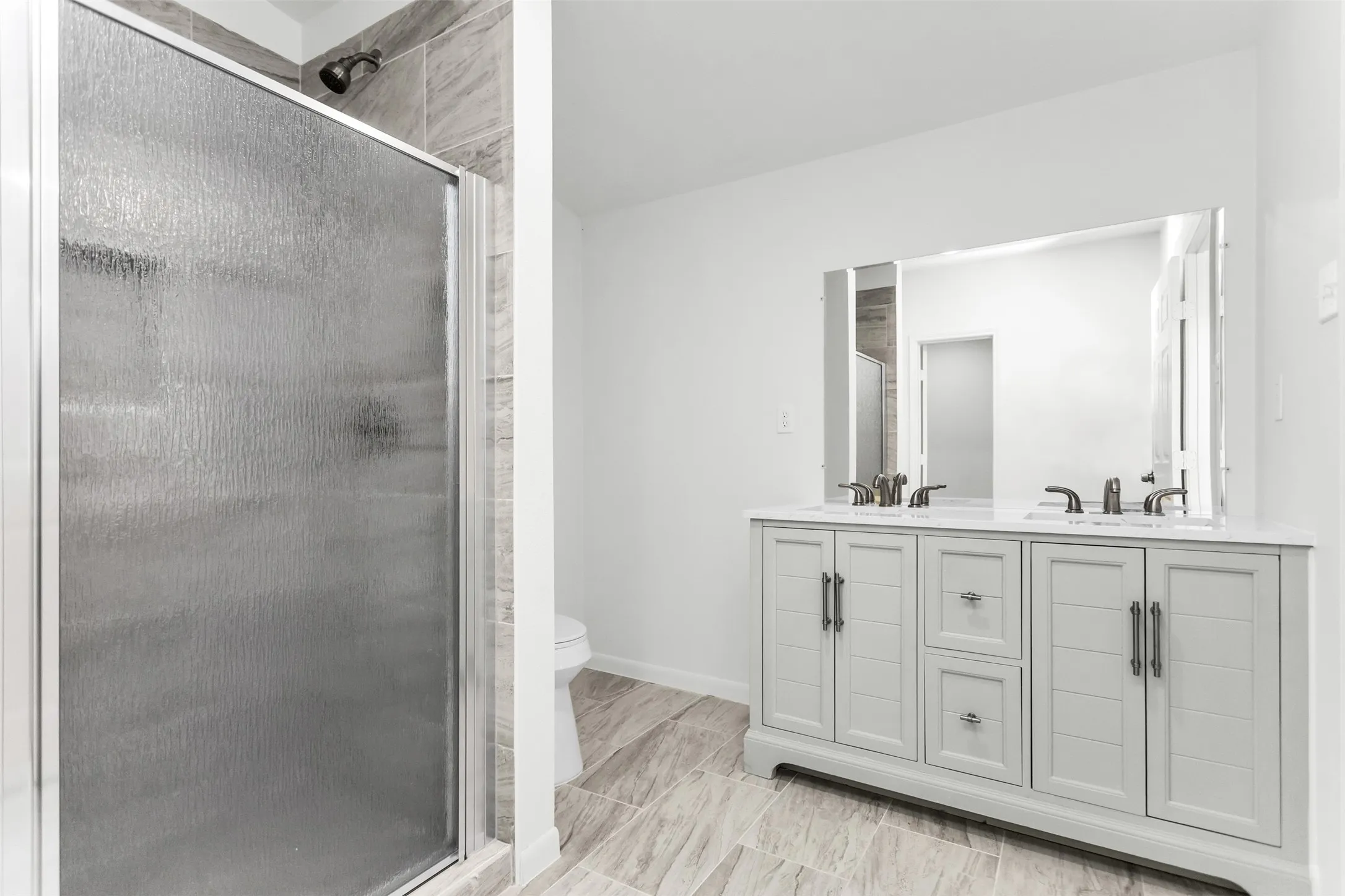 Dual vanity with white cabinetry, rectangular undermount sinks, and dark bronze-finish fixtures
