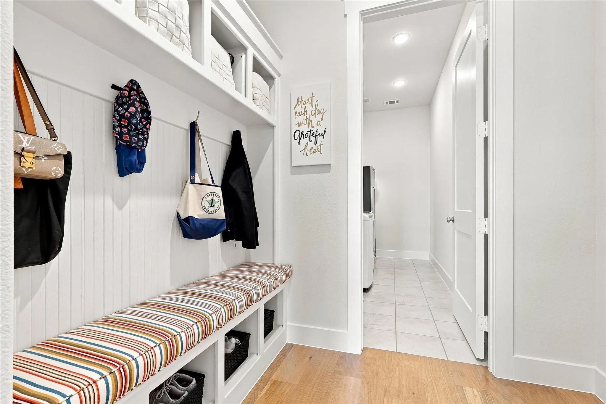 Built-in storage bench with overhead shelving and coat hooks