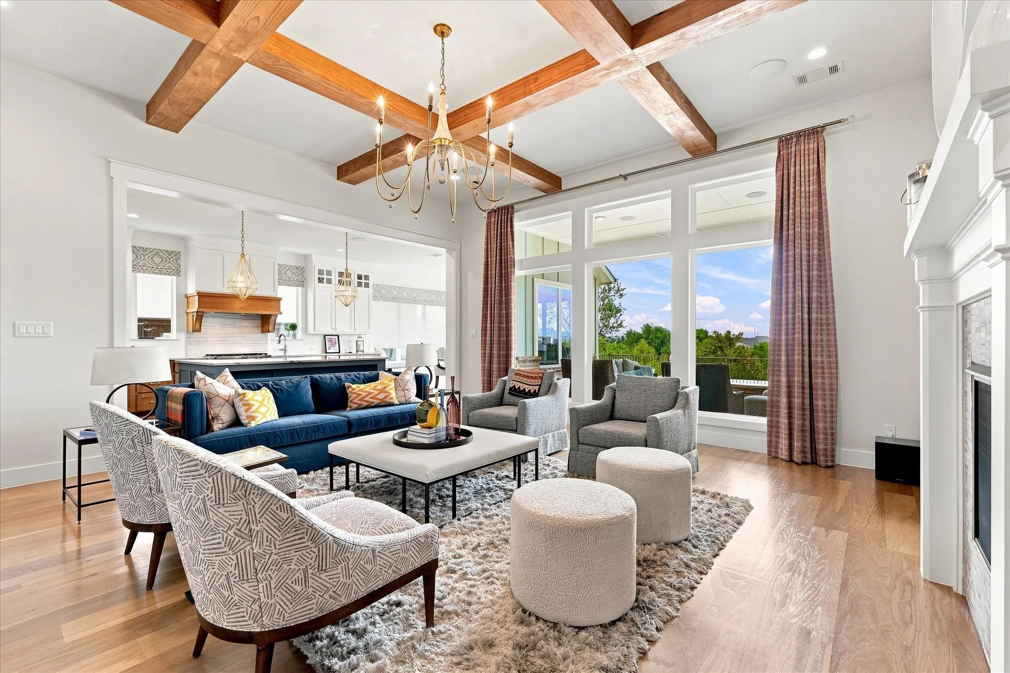 Vaulted ceiling with exposed wood beams, large picture windows, wood-finish flooring, and a built-in fireplace