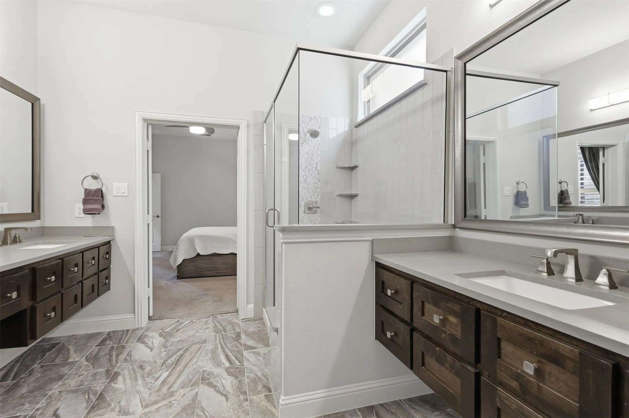 Dual floating vanities with integrated sinks, quartz countertops, and brushed nickel fixtures