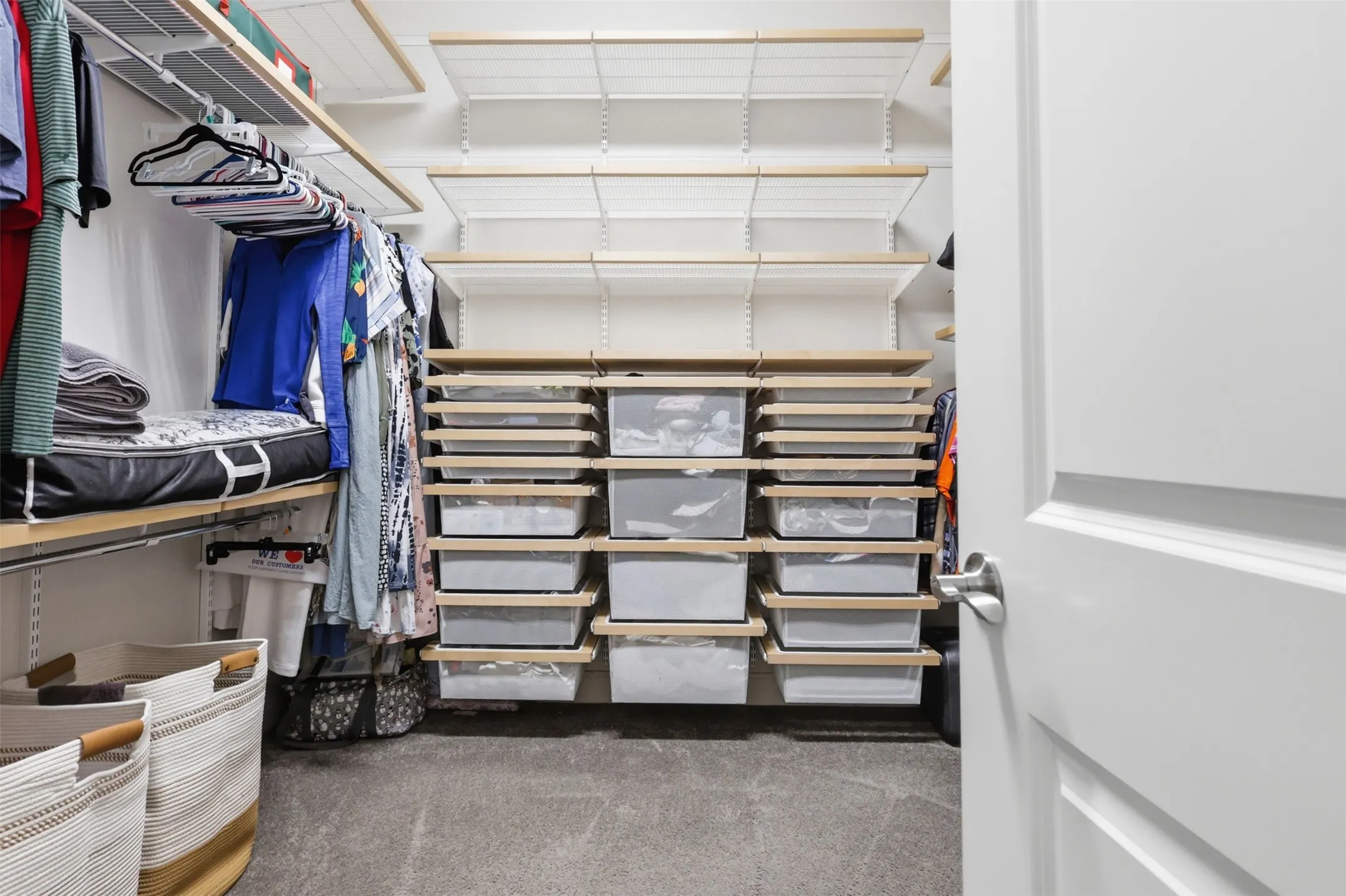 Custom closet system featuring adjustable shelving, integrated hanging rods, and wood-finish accents