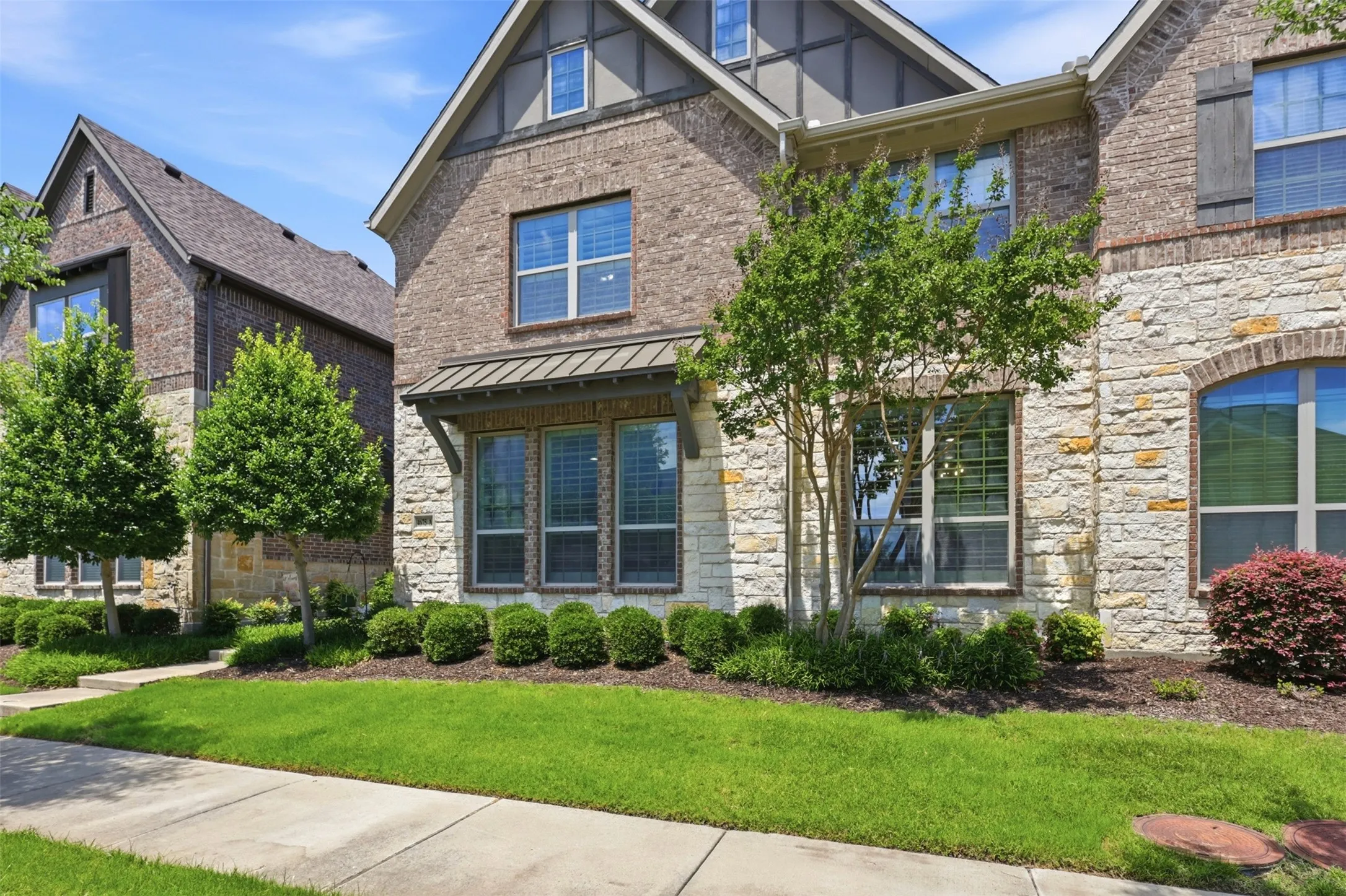 Brick and stone exterior with architectural shingles and decorative gables