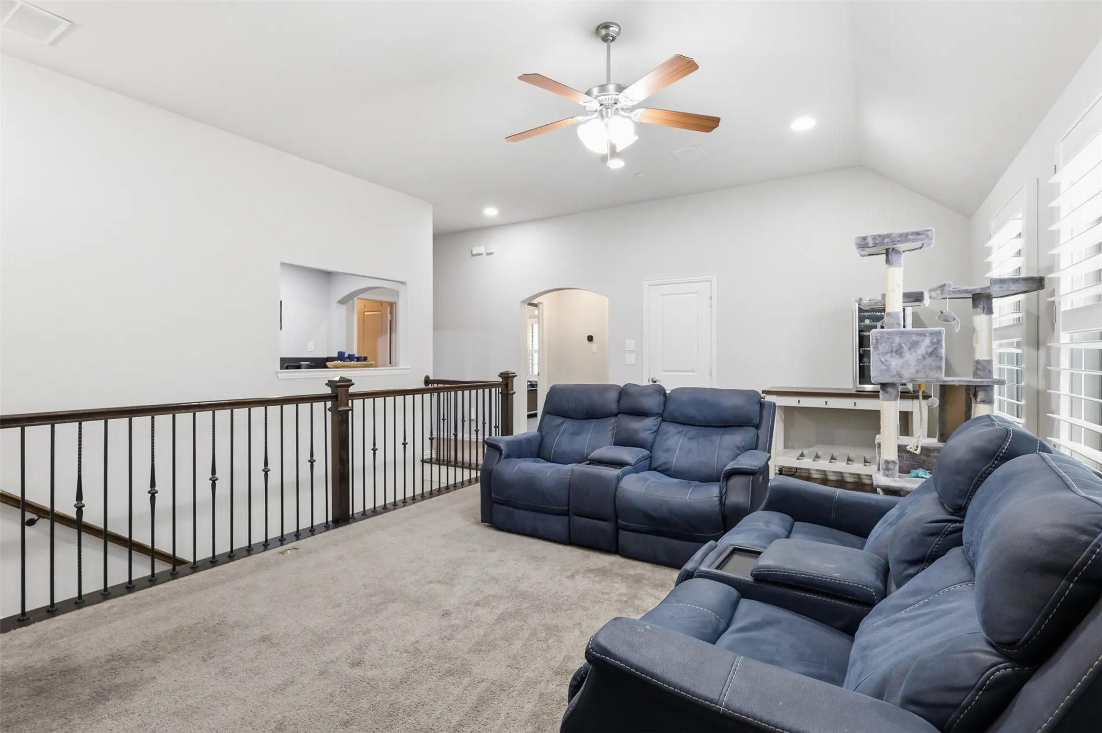 Spacious secondary living area featuring vaulted ceilings, recessed lighting, a ceiling fan, and carpeted flooring