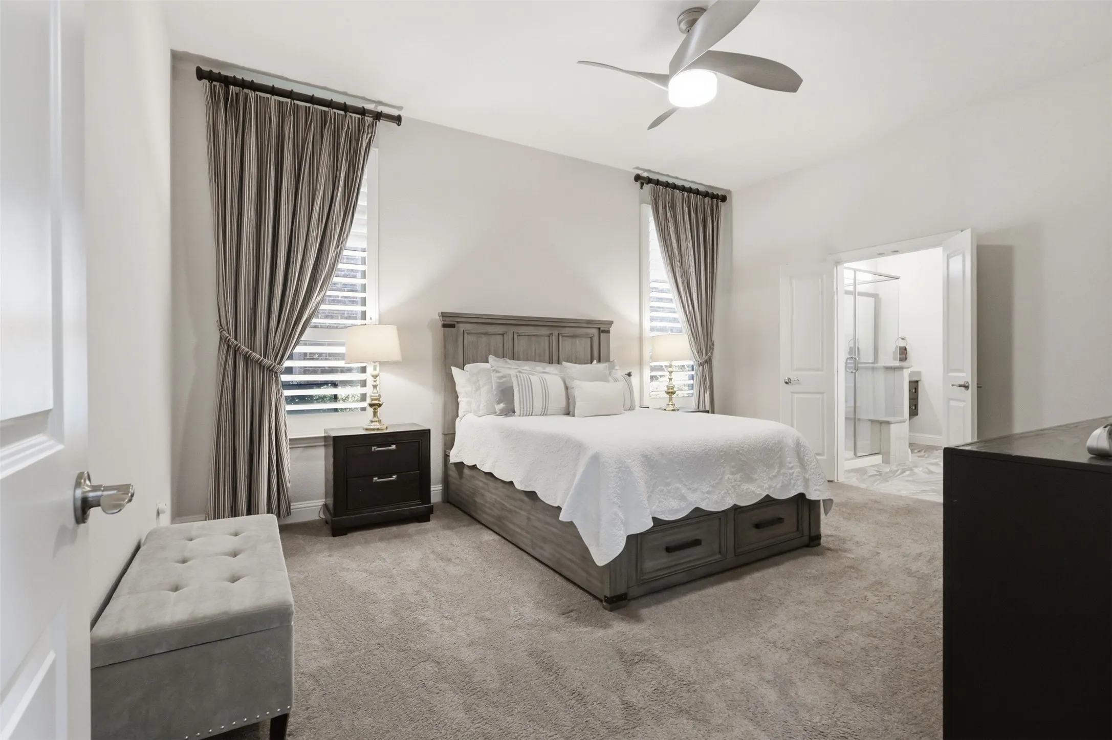 Carpeted room with a ceiling fan, recessed lighting, and an attached bathroom featuring a glass-enclosed shower