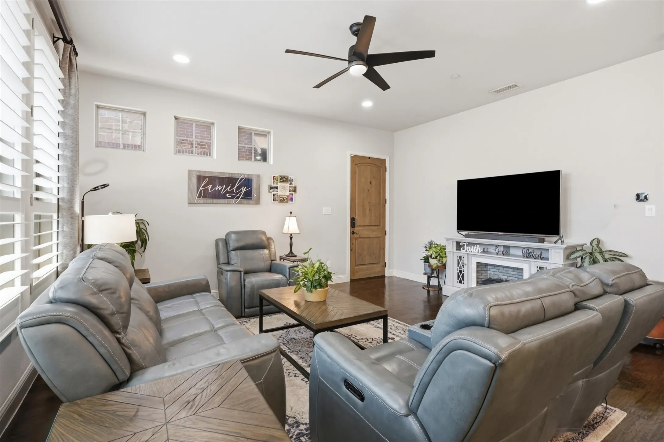 Recessed lighting, wood-finish flooring, ceiling fan, decorative fireplace, and interior wood door