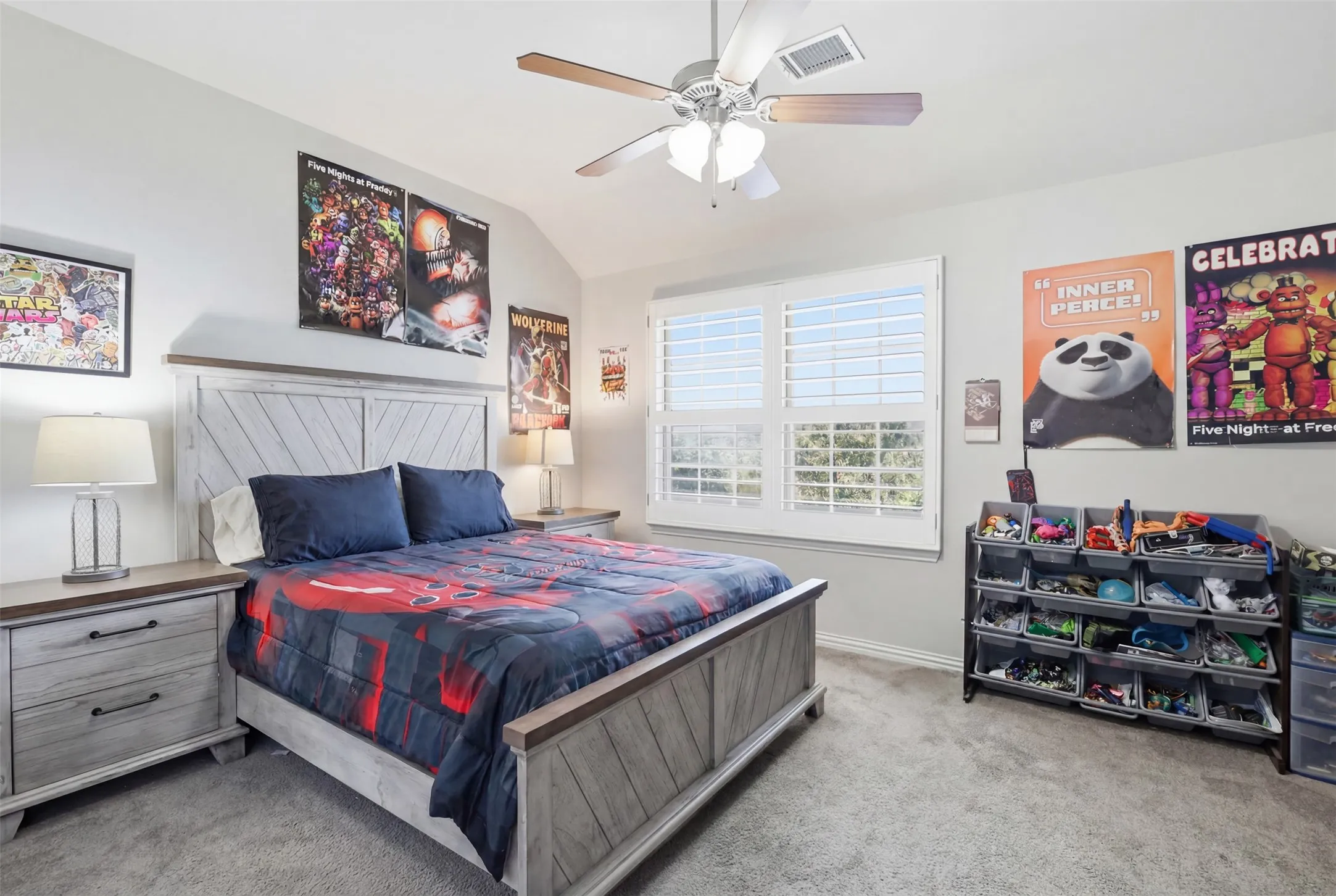 Carpeted room featuring a ceiling fan with light fixture, large window with plantation shutters, and light-toned walls