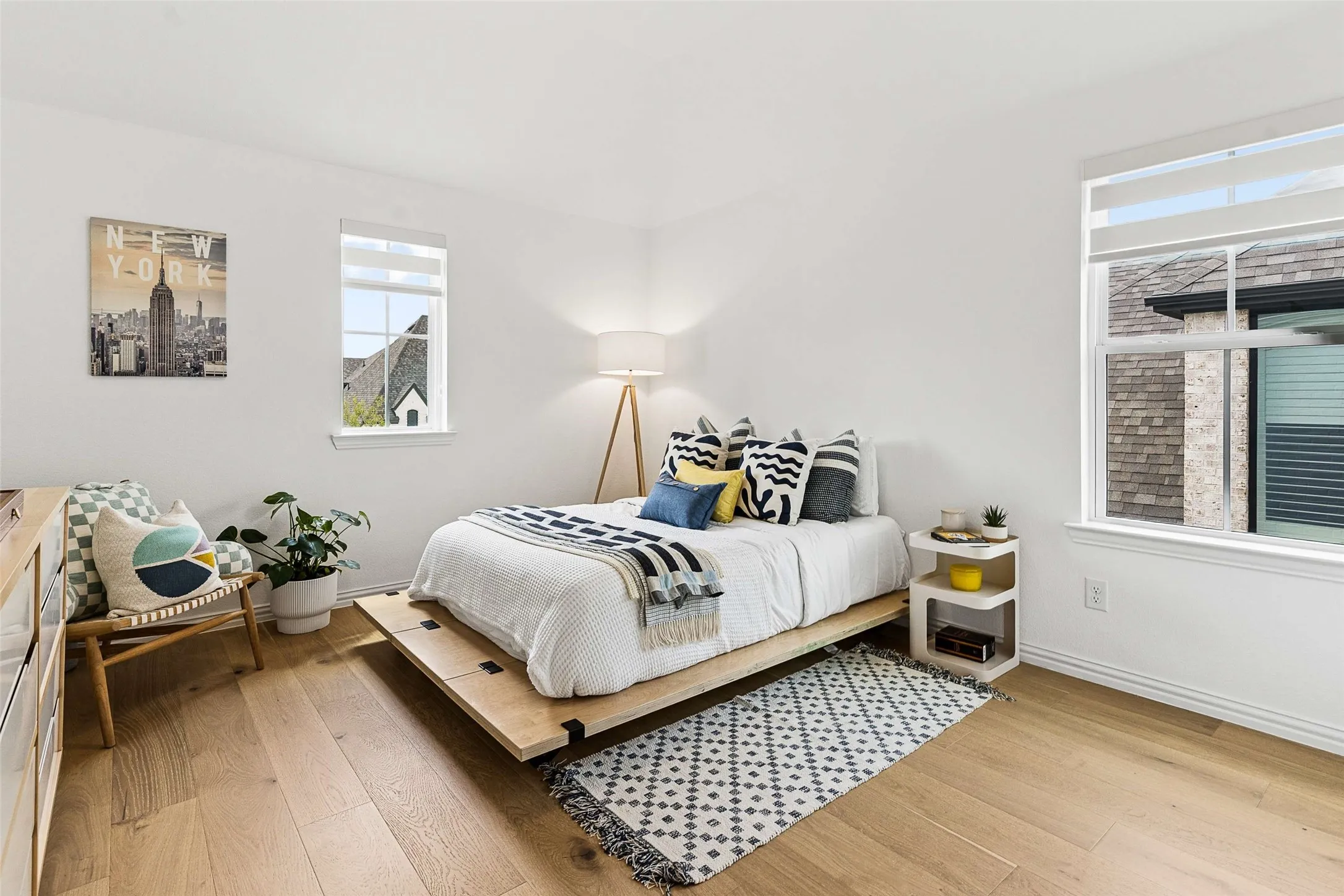 Spacious room featuring multiple windows, light wood-finish flooring, and white walls