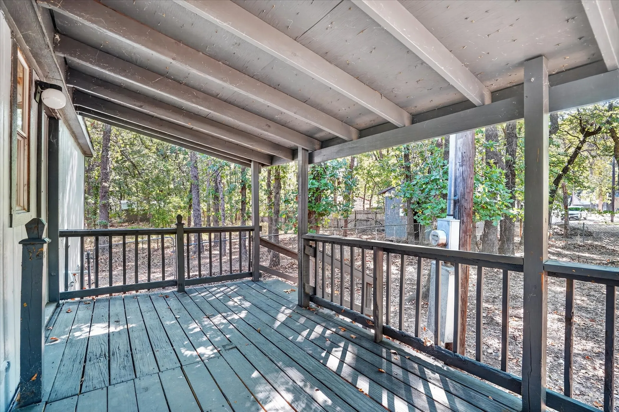 Covered porch featuring wood flooring, wood railing, and exposed ceiling beams