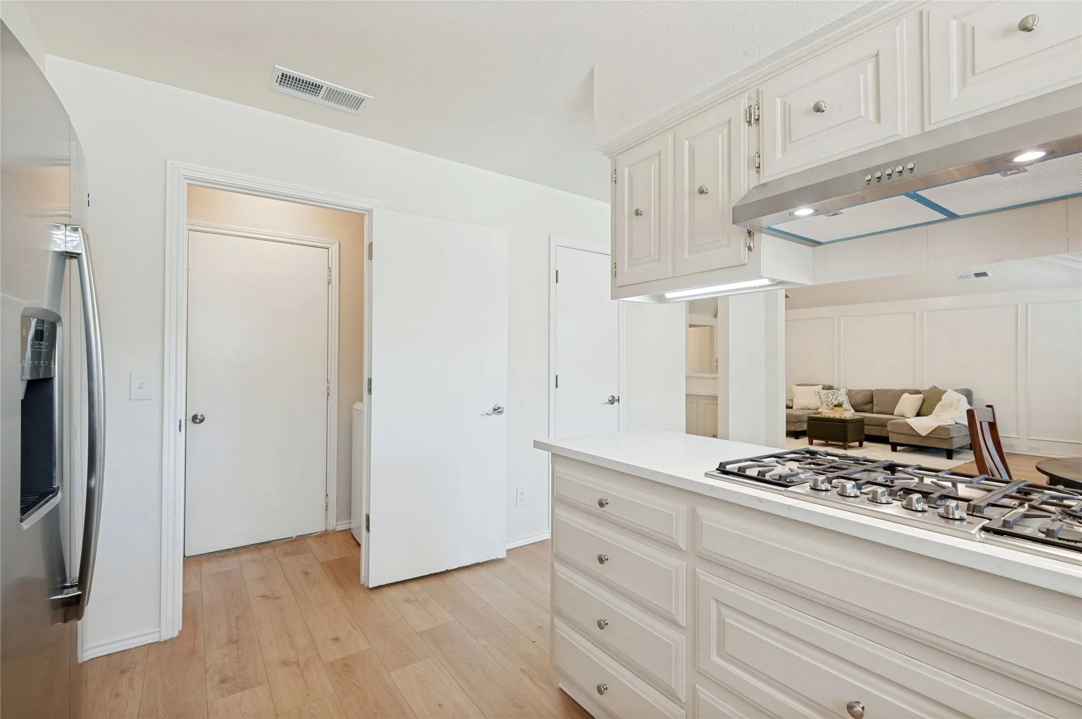Views from the kitchen into the wet bar, pantry, utility room, dining room, and access to the 2-car garage
