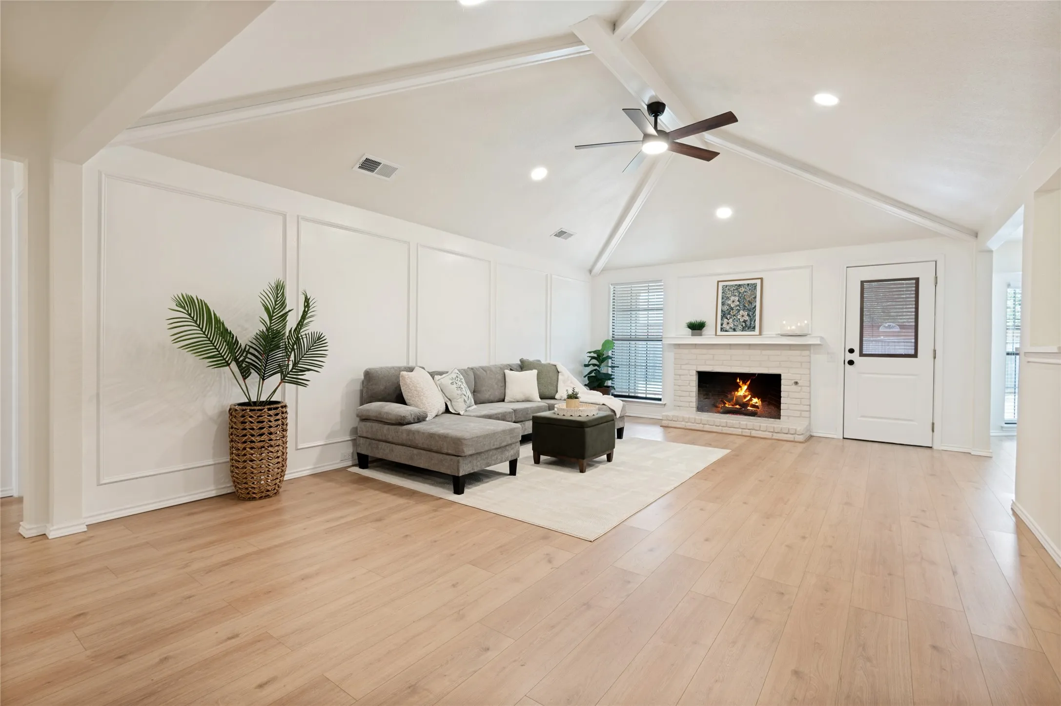 From the front foyer, enter into this absolutely beautiful open-concept living room featuring vaulted ceilings, views to the backyard, and entertaining connection to the wet bar, dining area, and chef's kitchen.