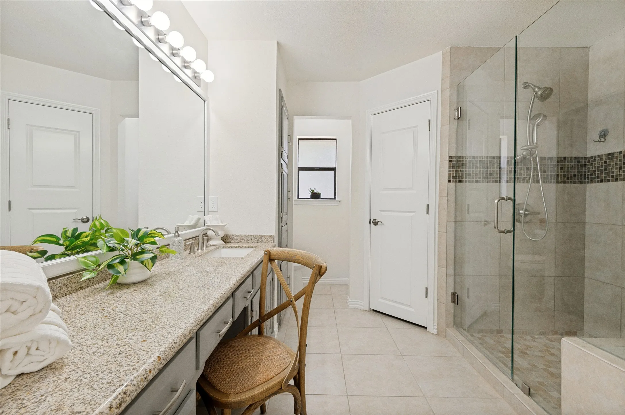 Primary Bathroom Ensuite - fit for royalty!  Shower built for 2 including a bench seat for comfort and functionality.  There is even an area to sit and do your hair/makeup.  Views of 1 of the 3 walk-in closets provided in this suite.